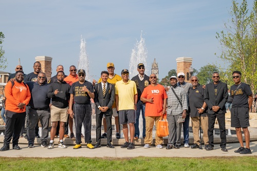  A group of 18 men poses in front of a fountain