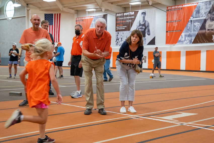 Olympic gold medalist Dave Wottle '73 cheers on a young runner during the 800 meter kids run at Perry Fieldhouse.