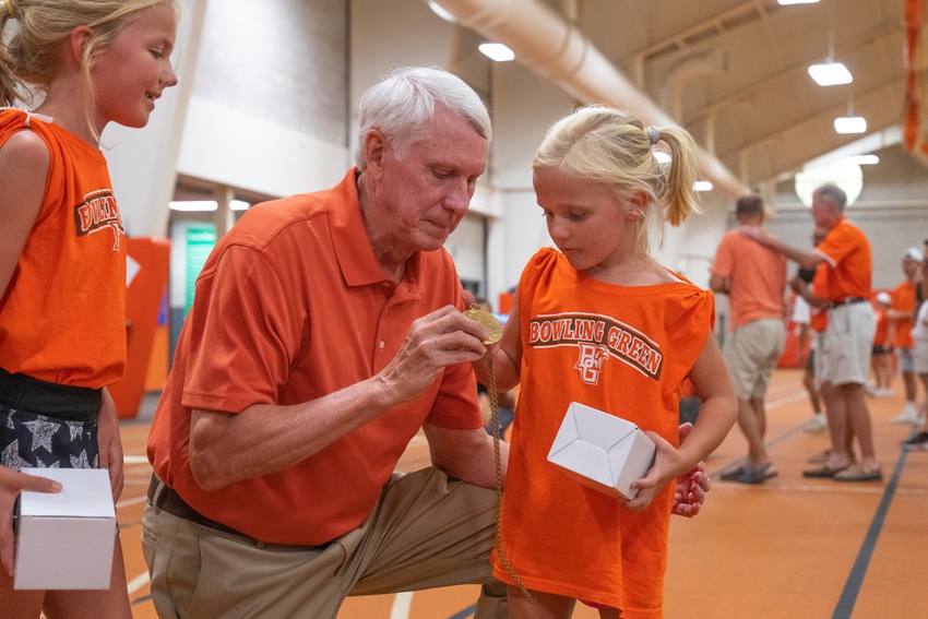 Two young runners spend a moment with BGSU alumnus Dave Wottle as he shows them his gold medal from his 1972 Munich Olympics 800 meter race.