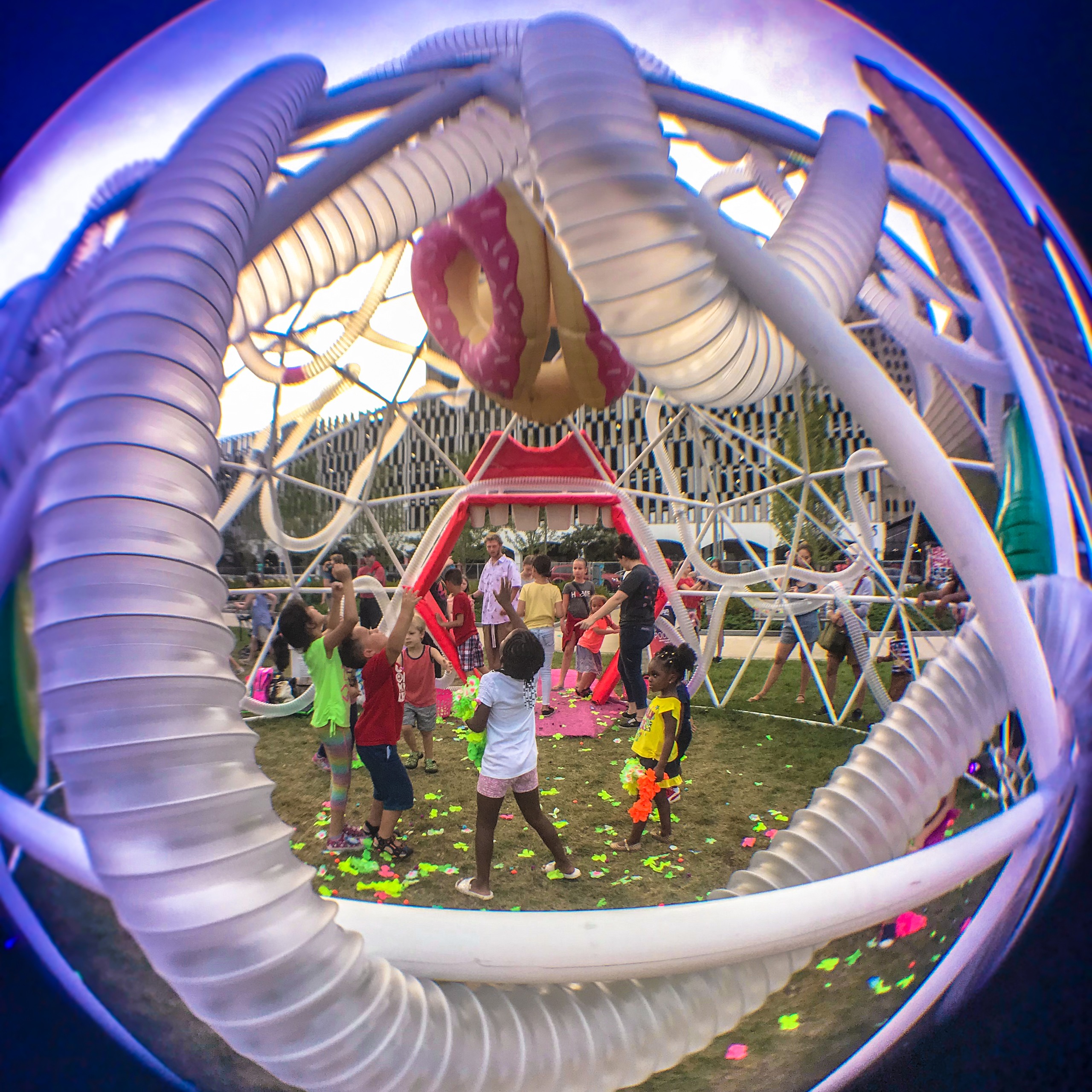 Children play in a large modern art sculpture