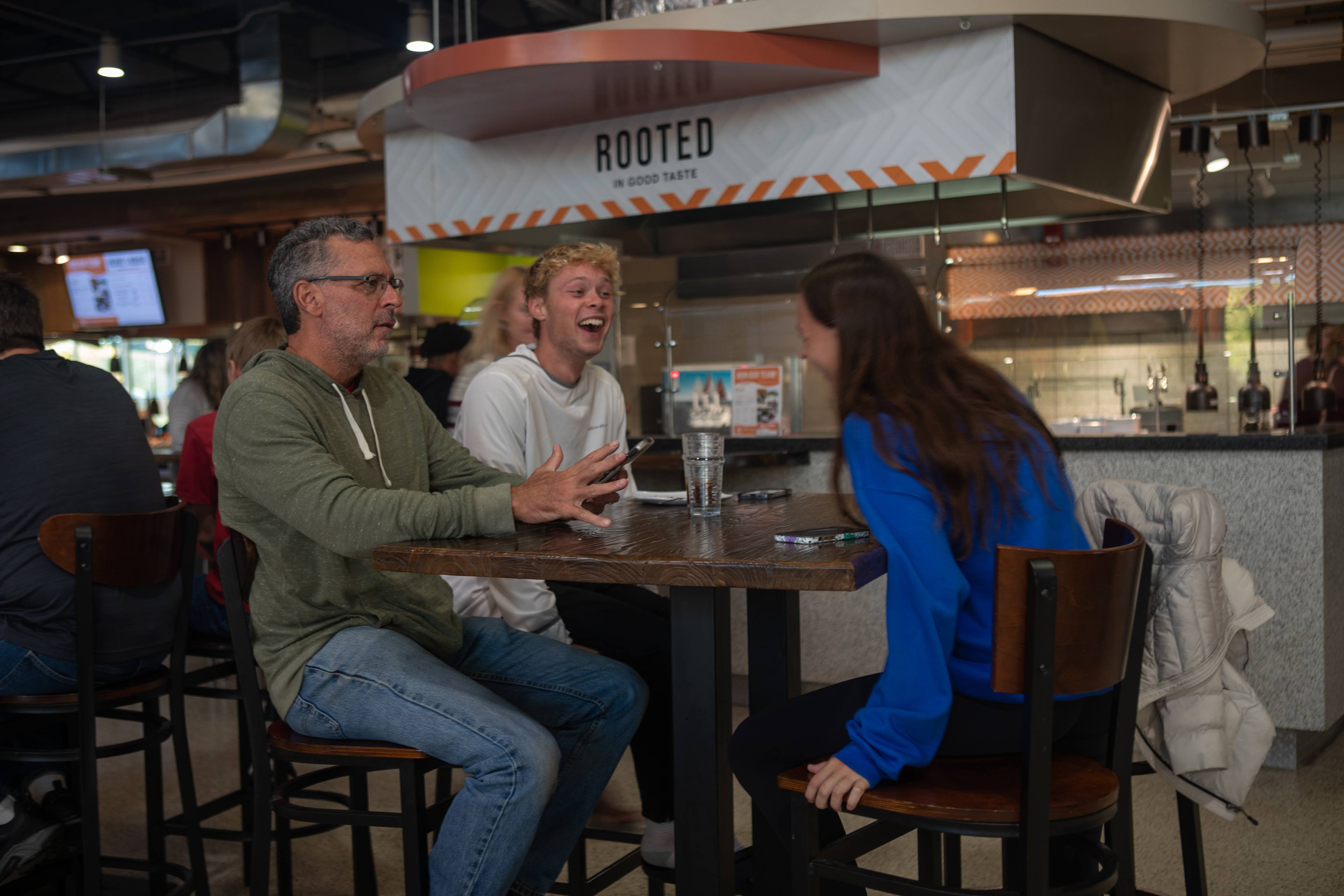 Three people at a table laughing