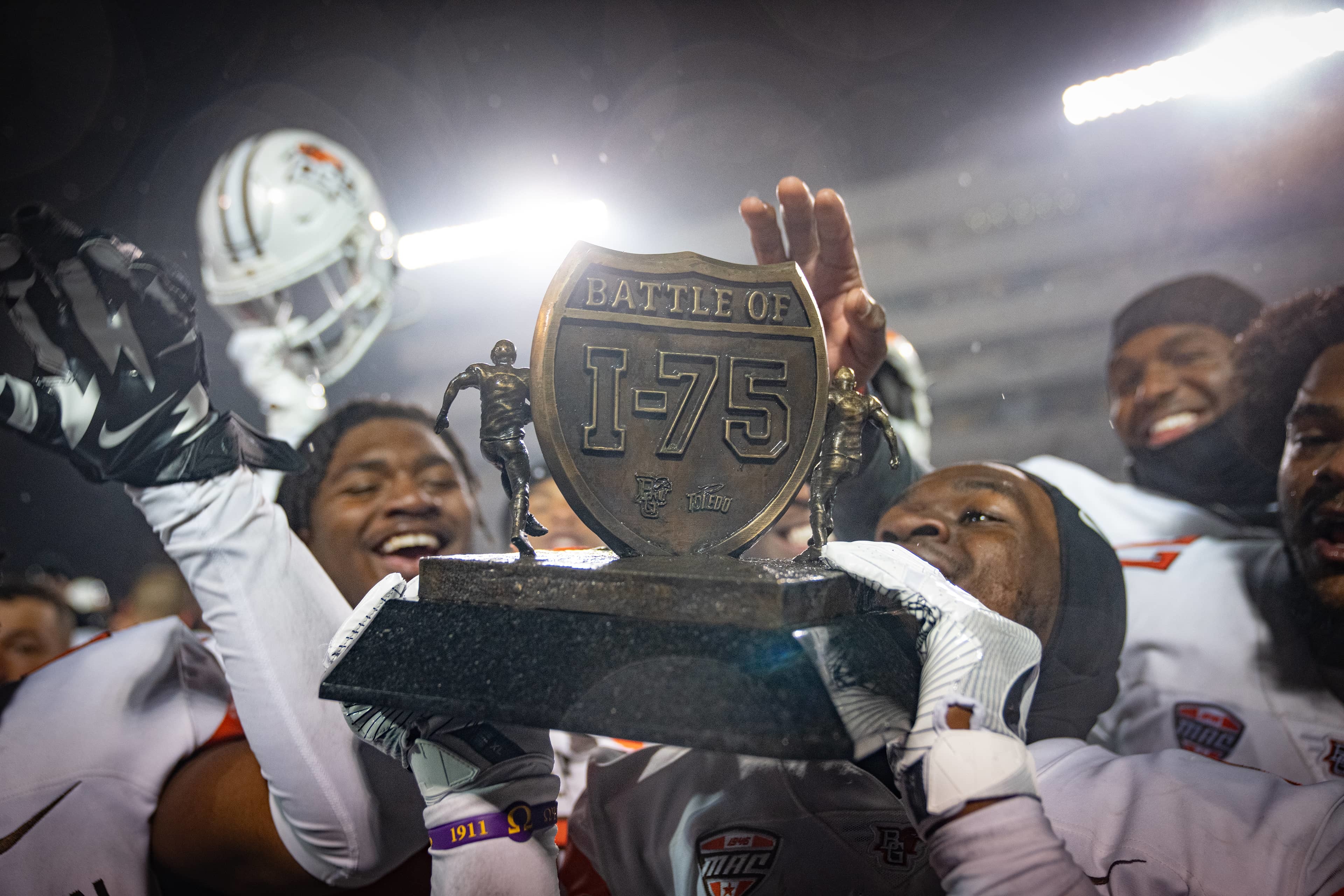 BGSU football players hold a trophy