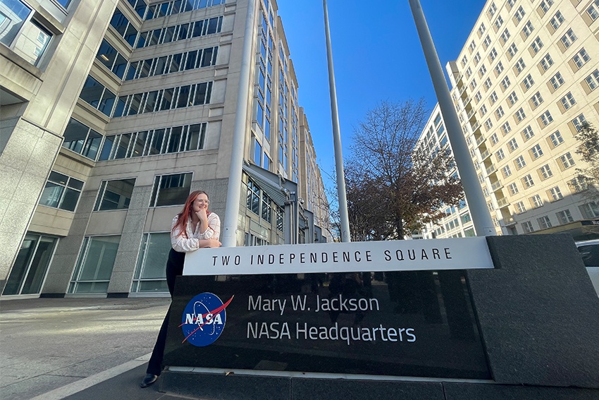 Heather Monaghan leaning on NASA headquaters sign