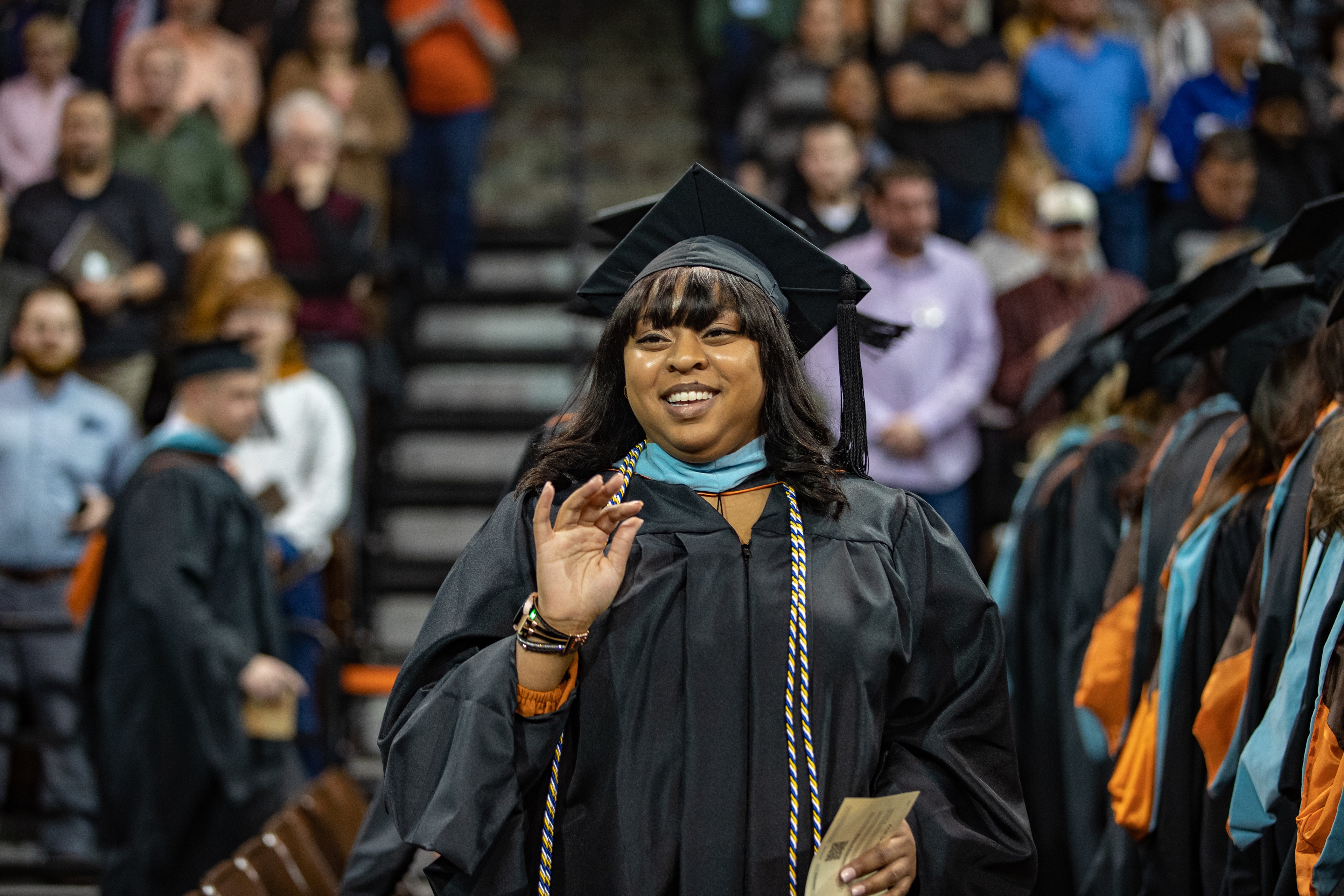 BGSU graduate smiles and waves during Commencement