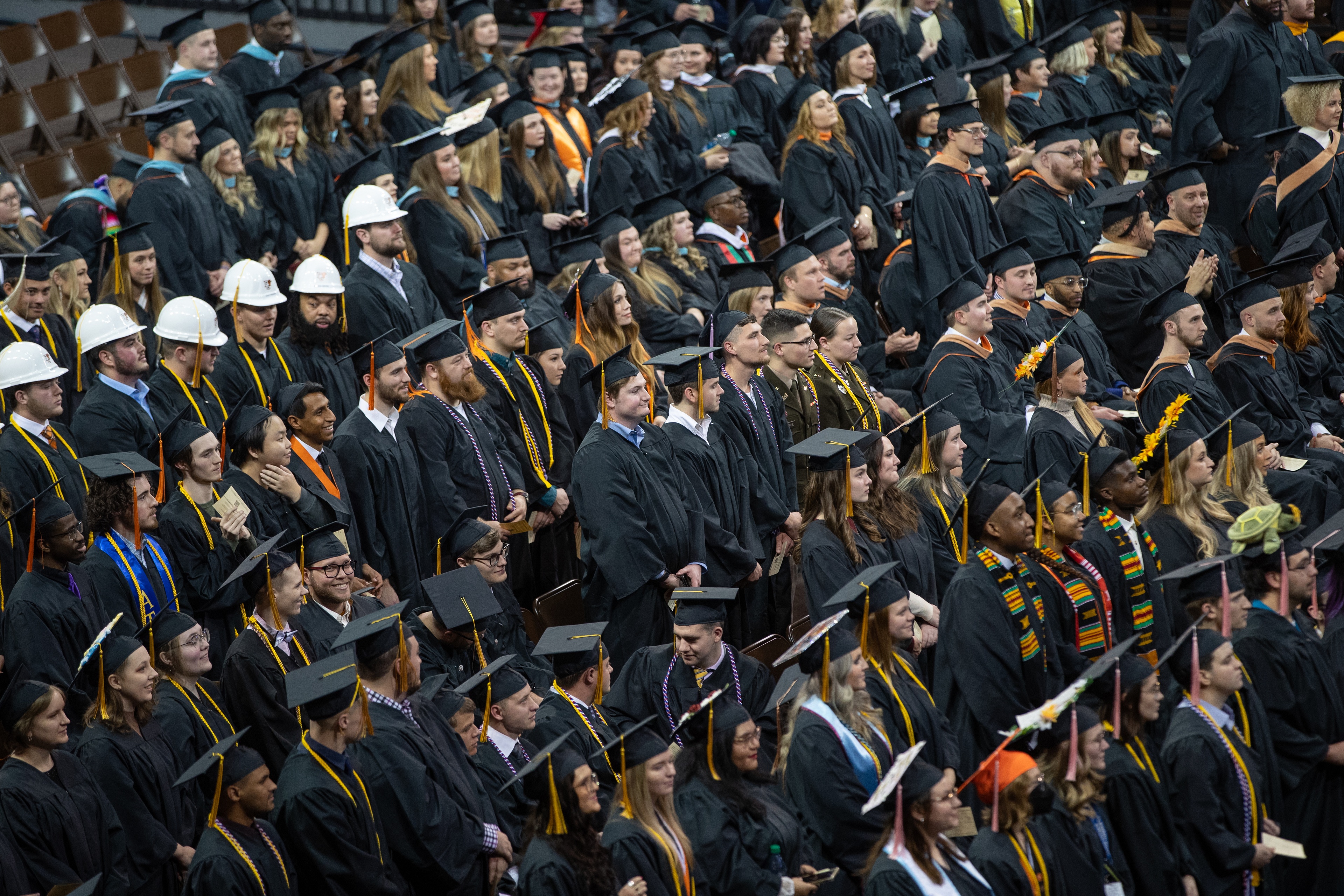 Graduates stand at the Stroh Center