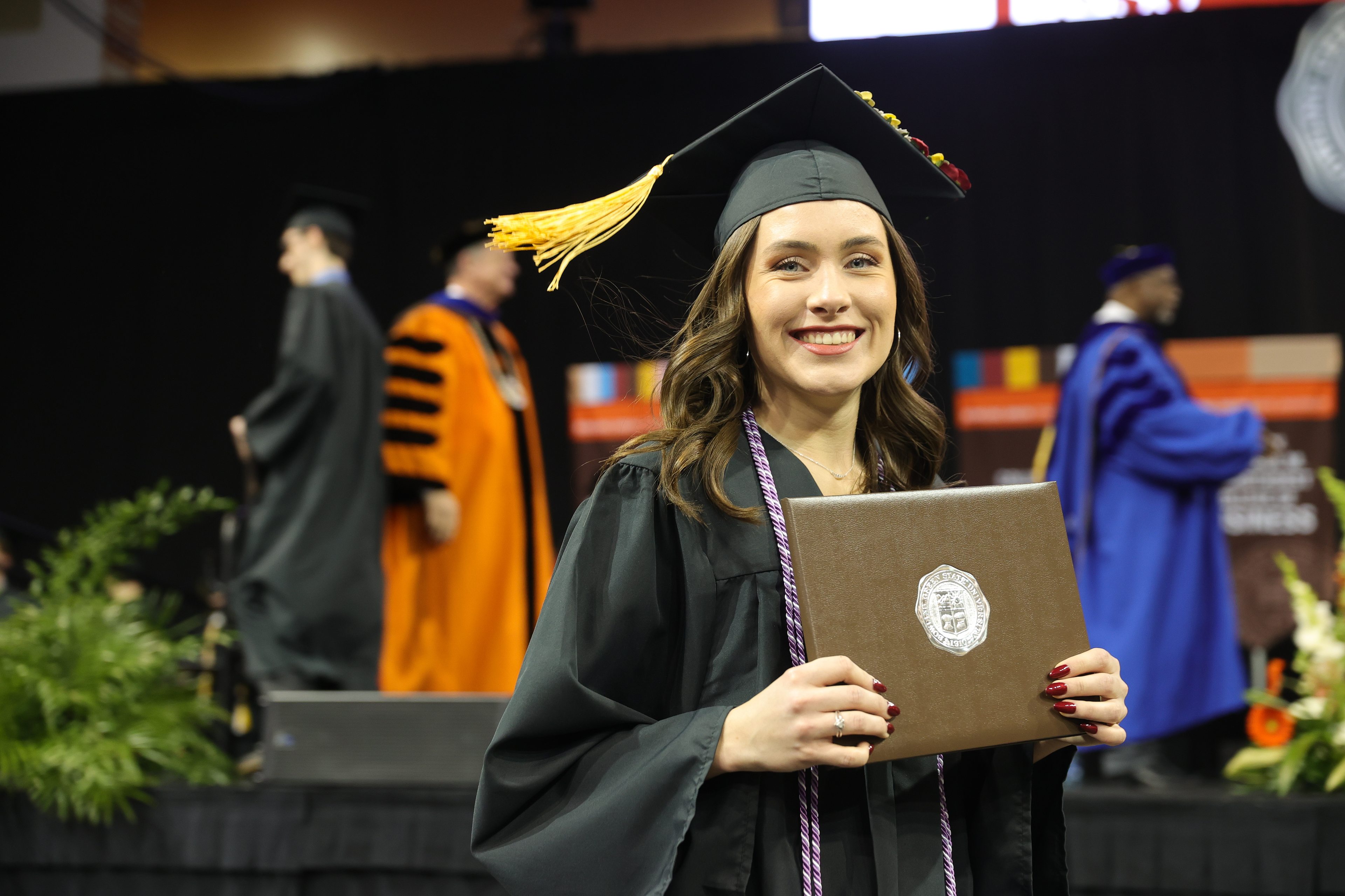 Female graduate holds her diploma cover 