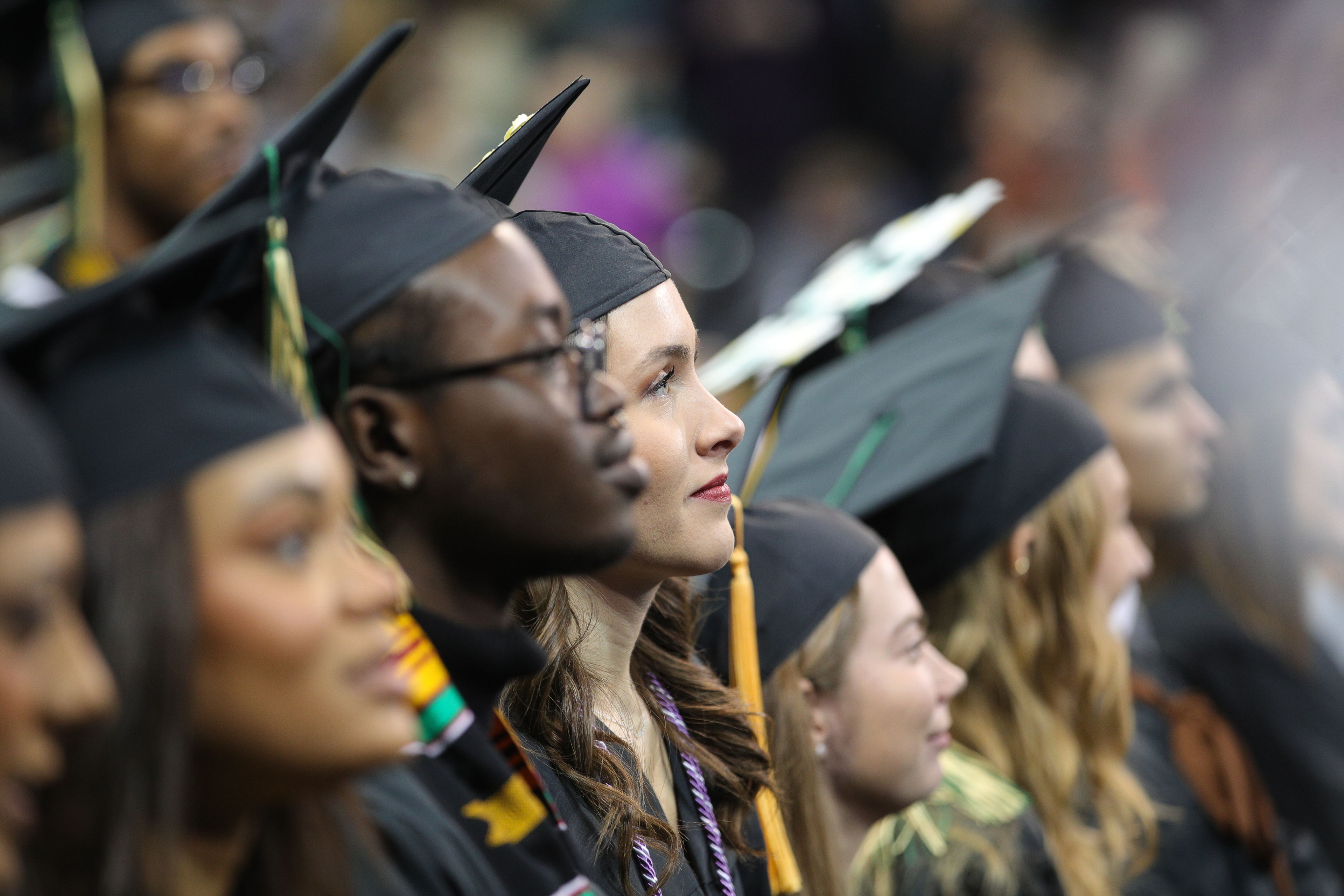 Group of graduates looks toward the stage