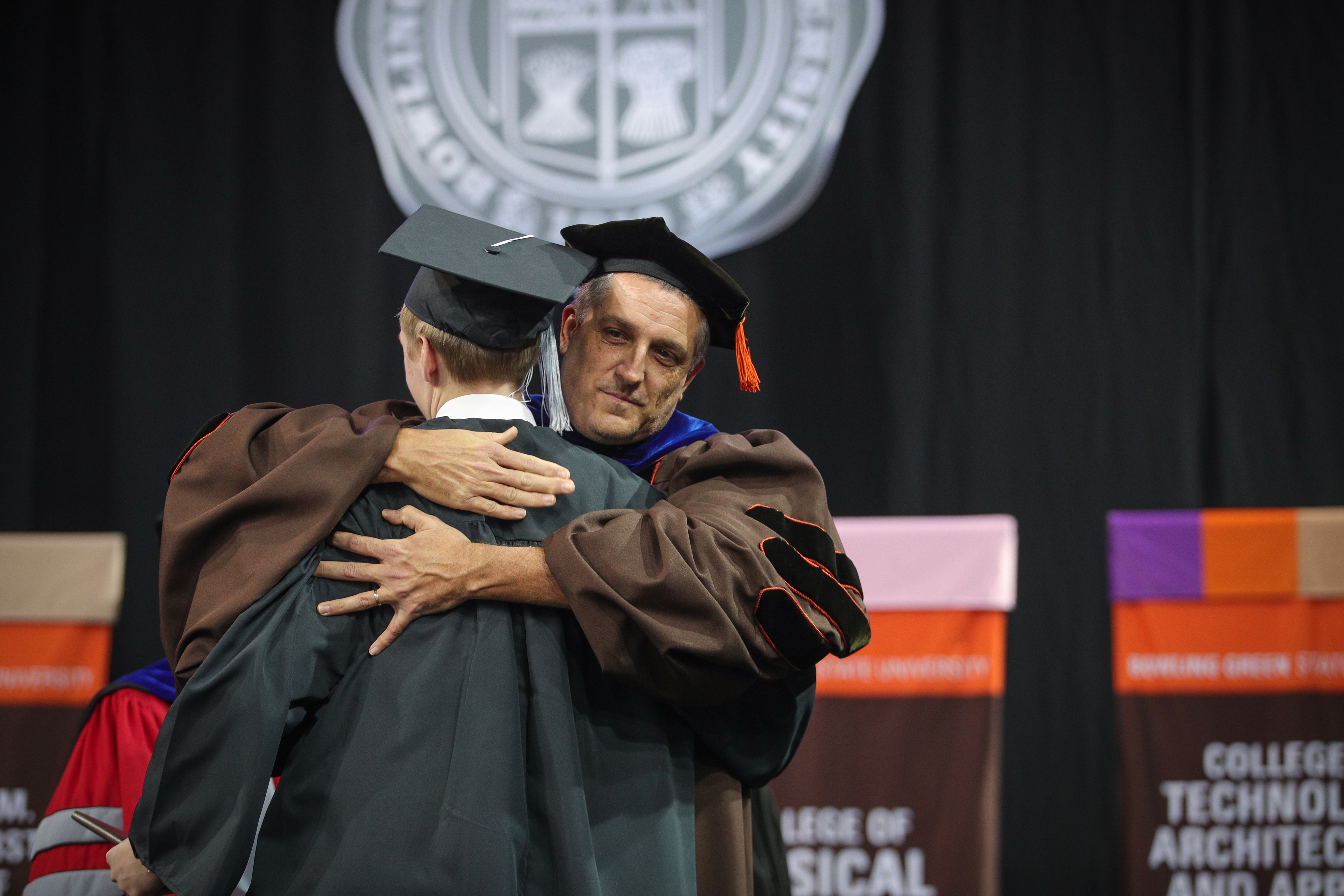 Alumnus Brady Gaskins hugs his graduating son, Zachary Wells Gaskins