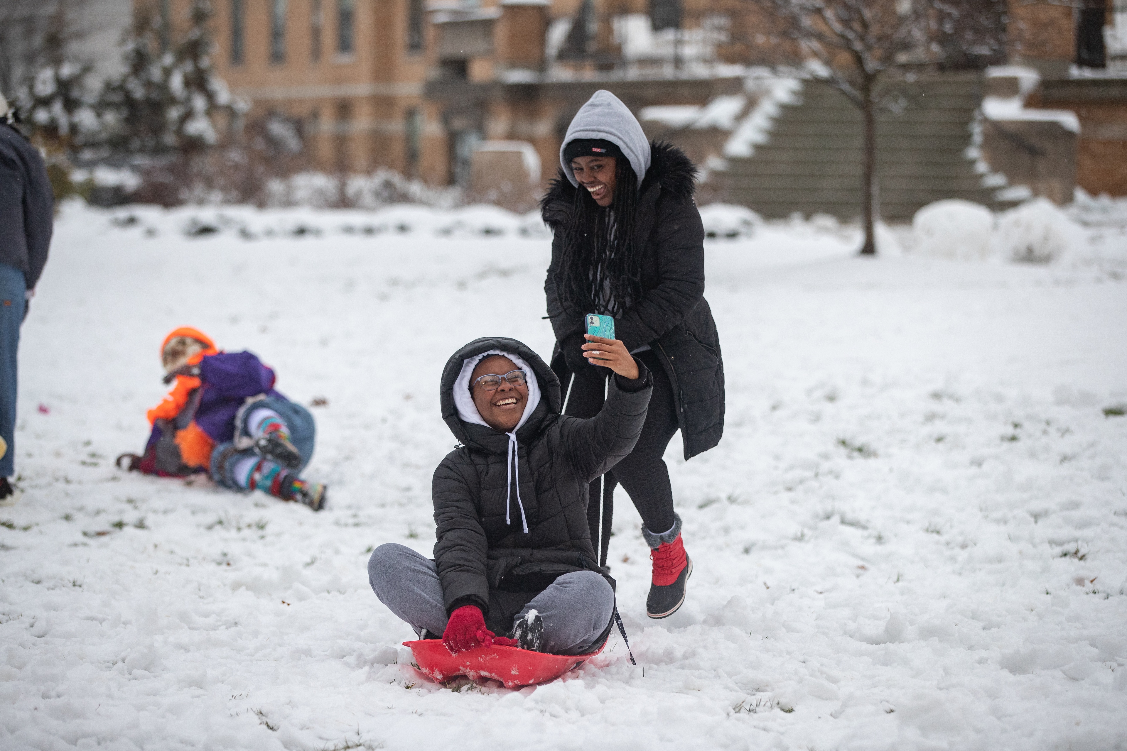Two students take a selfie on a sled
