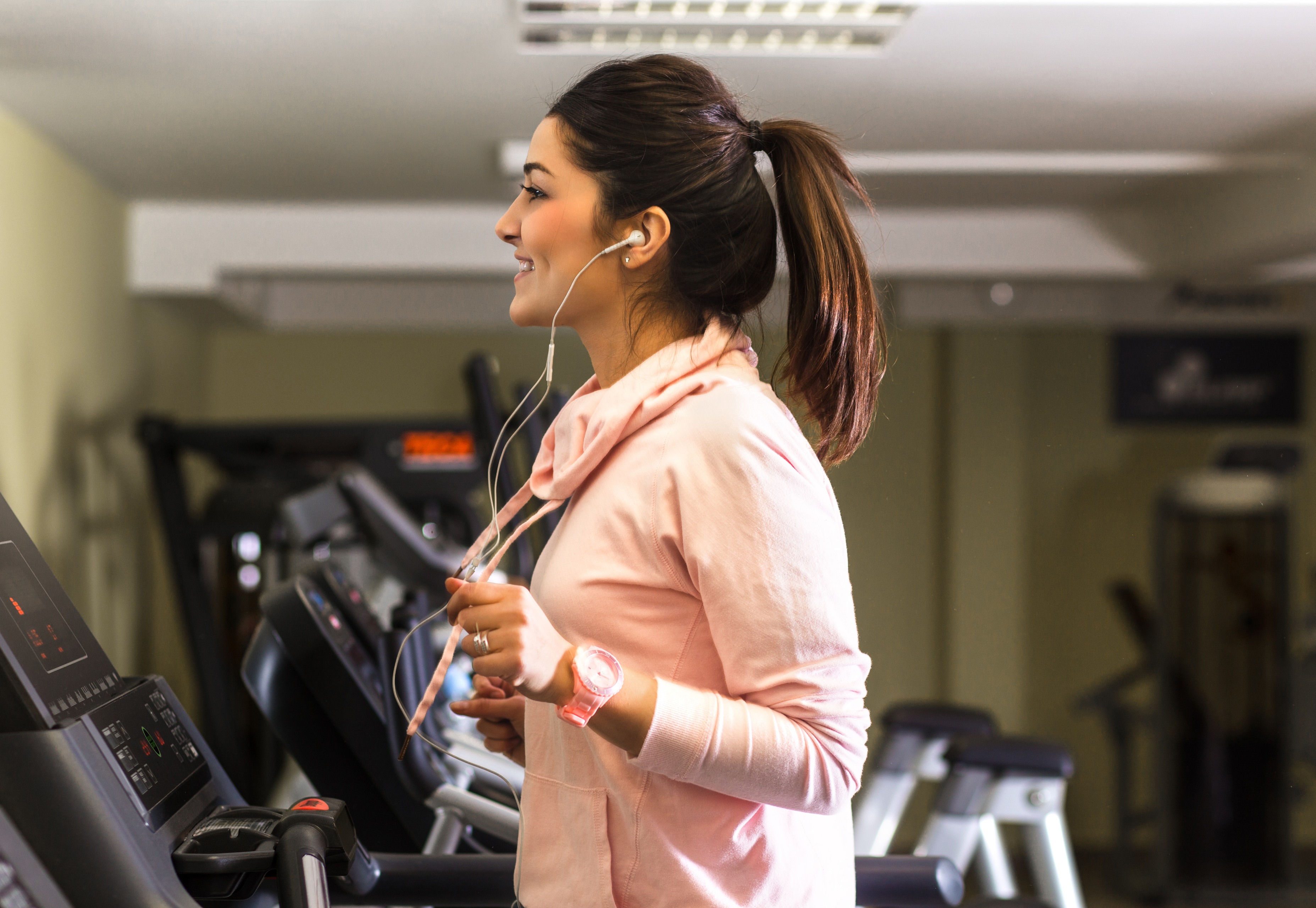 woman running on treadmill listening to music