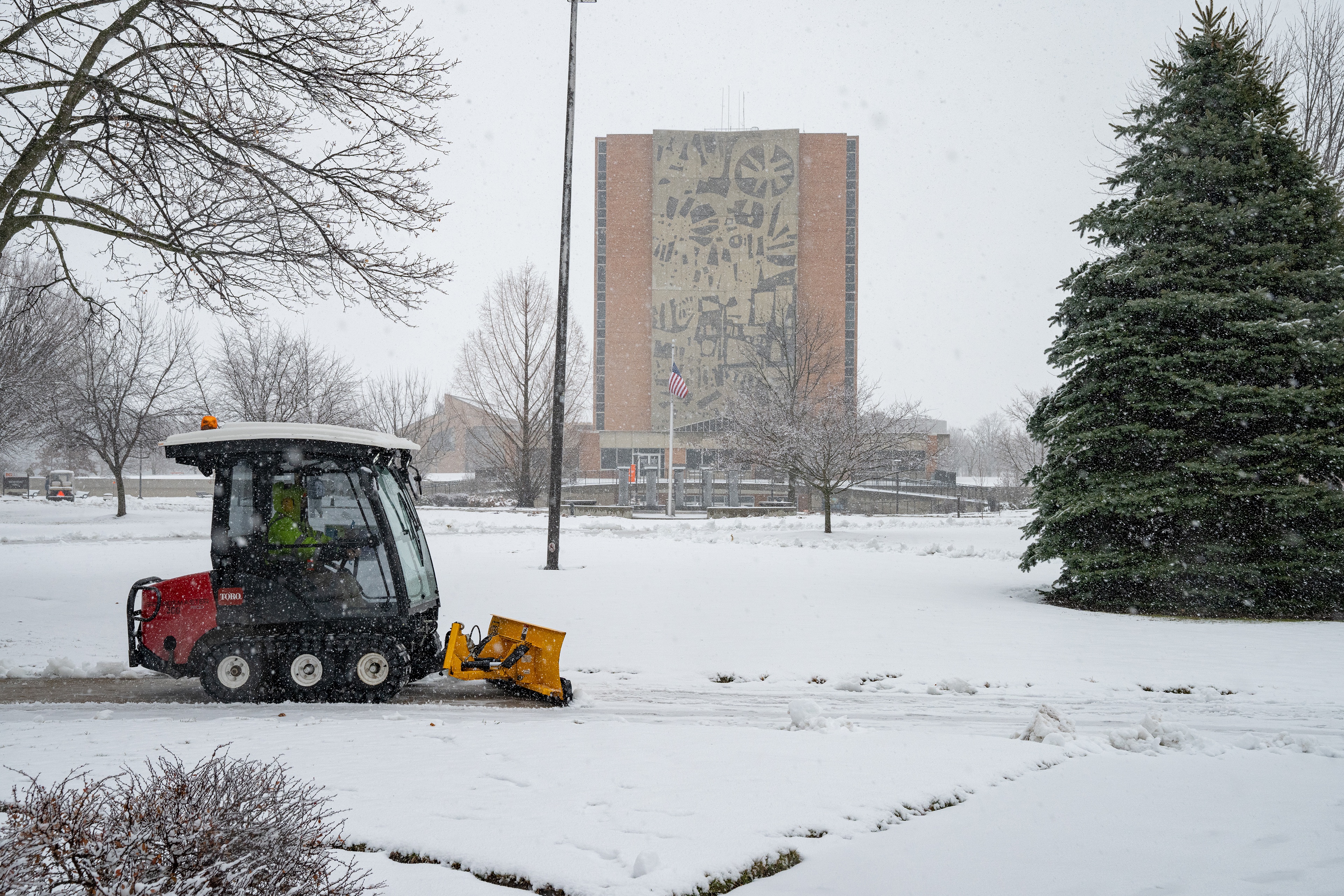 A snow removal tractor clears snow on BGSU campus