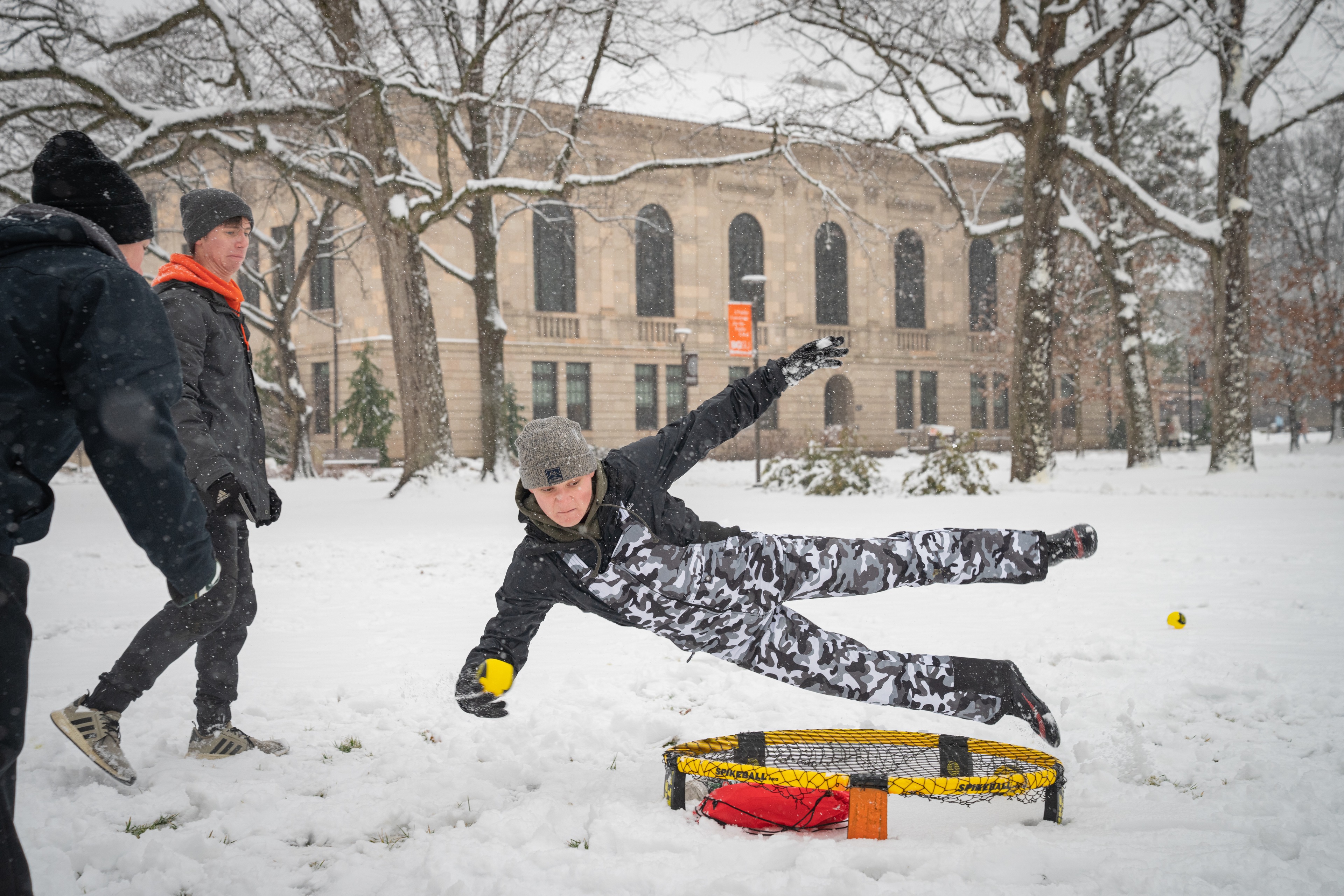 Students play spikeball in the snow