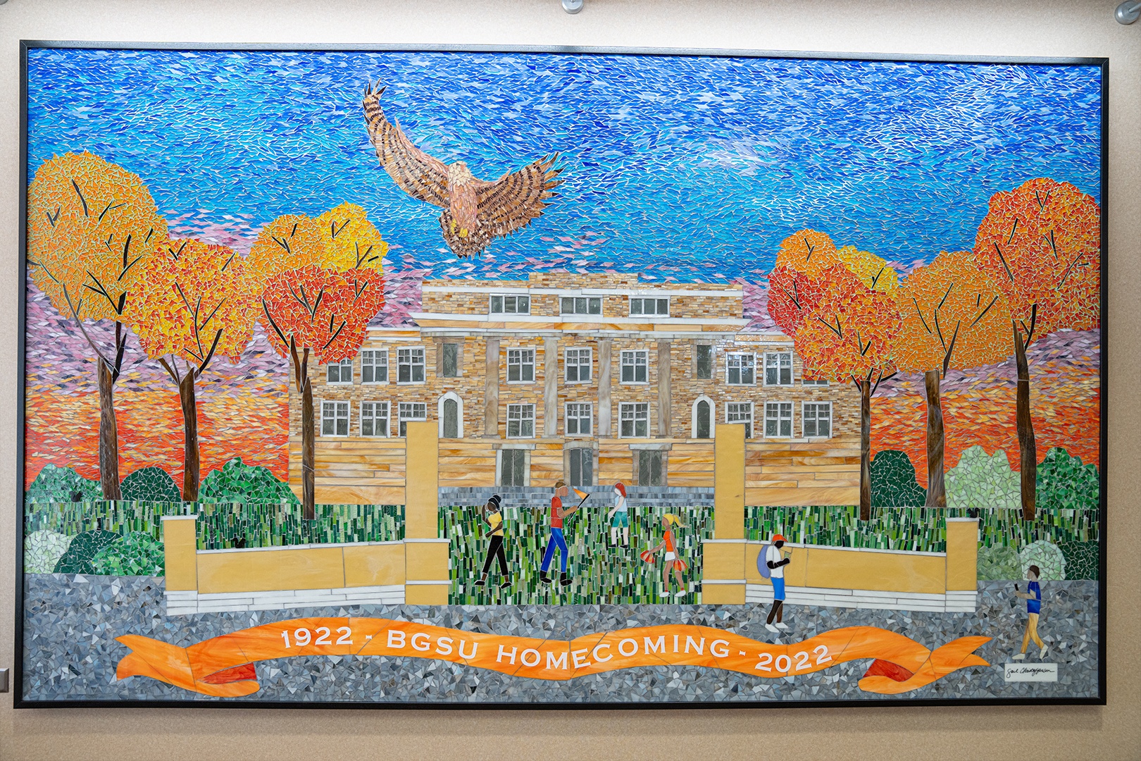 100th BGSU Homecoming mosaic shows University Hall, the Alumni Gateway, students walking, trees and a falcon flying above it all