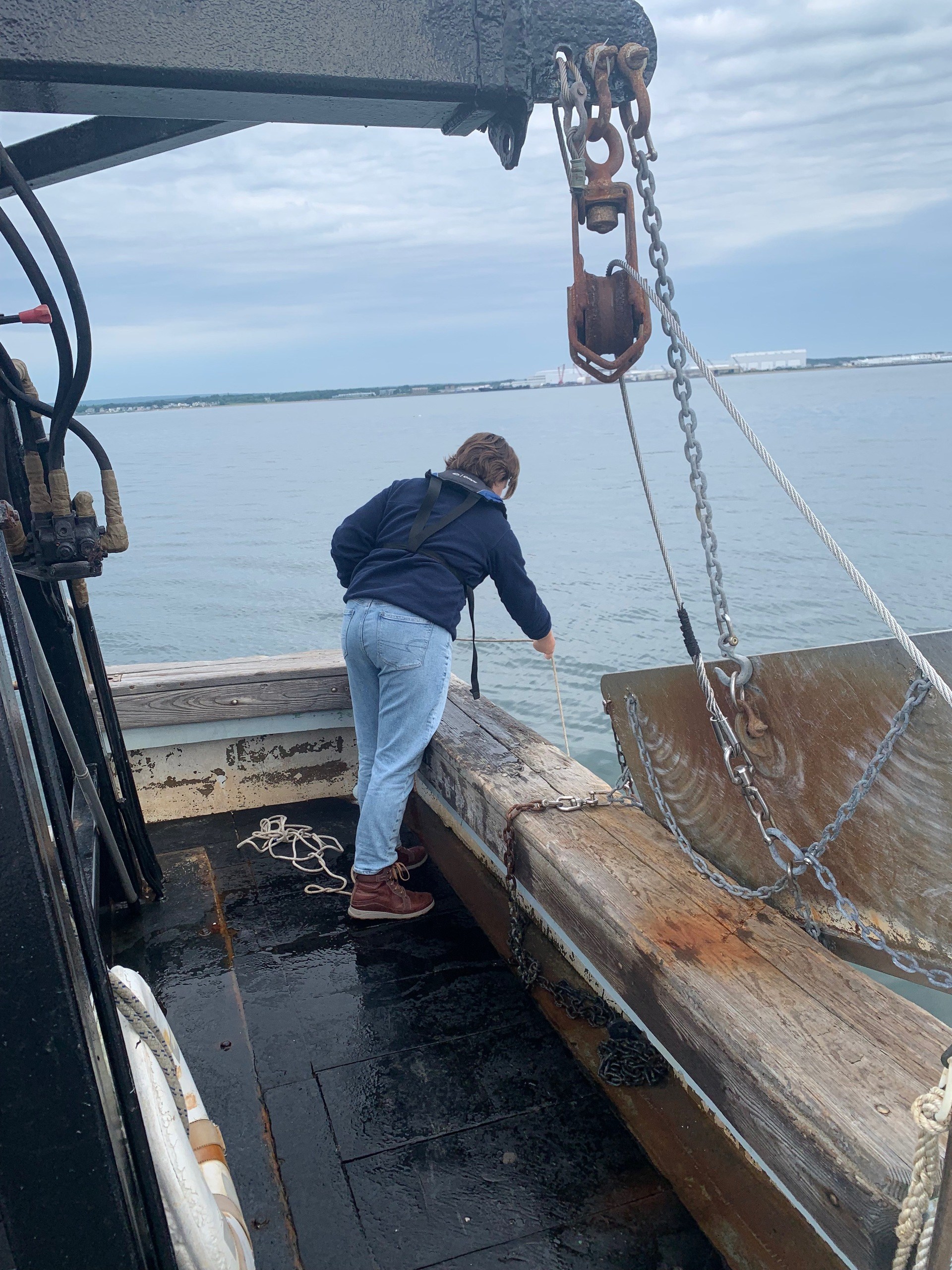Margaret leaning over boat to collect plankton