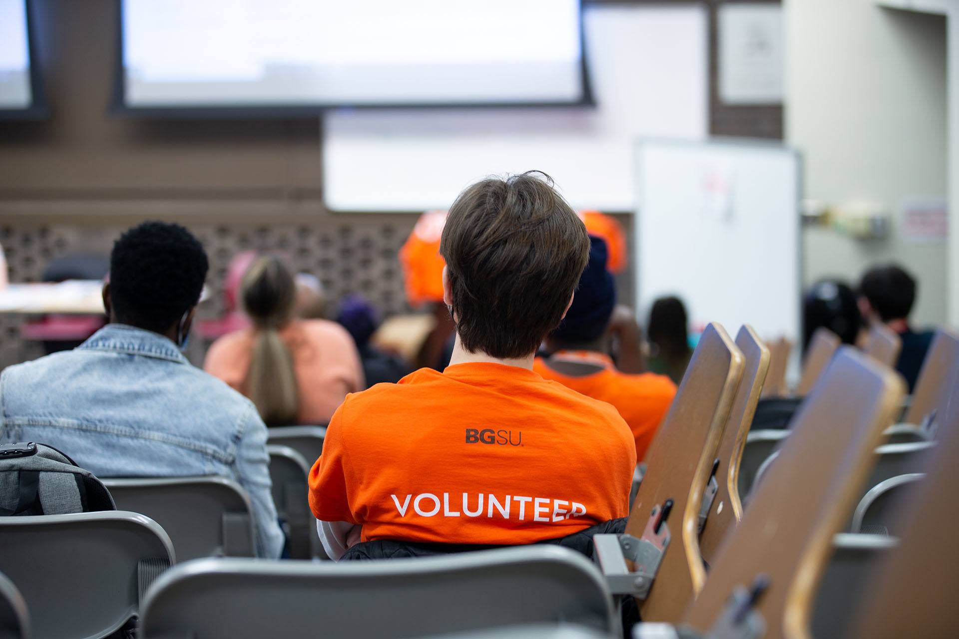 BGSU student wears an orange volunteer shirt.