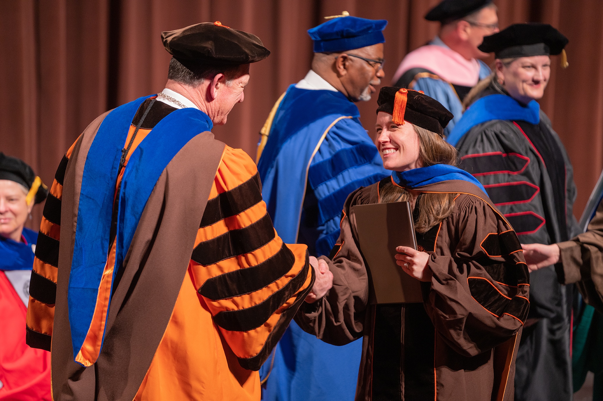BGSU President Rodney K. Rogers shakes hands with doctoral student Abigail Sarah Jarosz