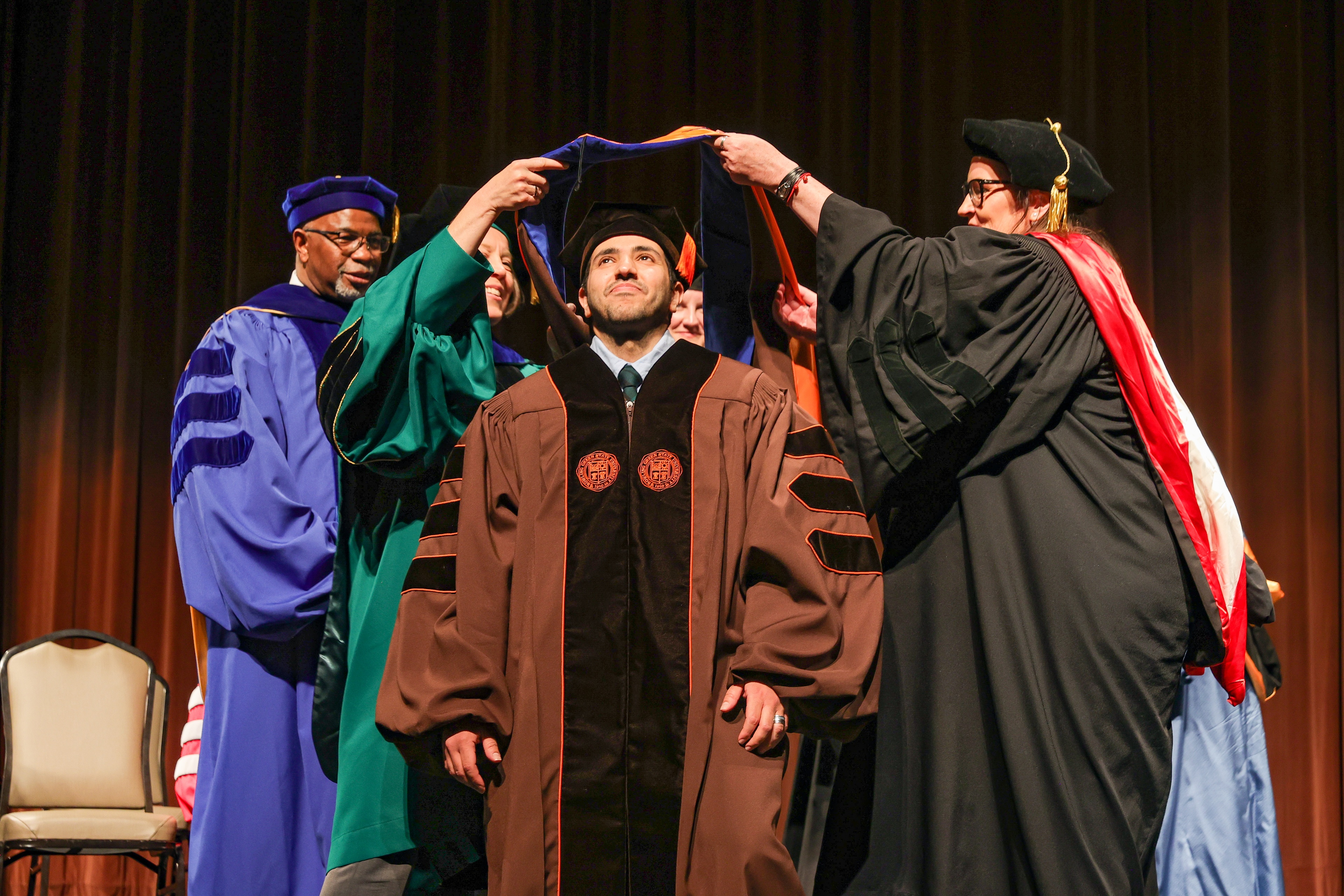 A BGSU doctoral student is hooded on stage at Kobacker Hall