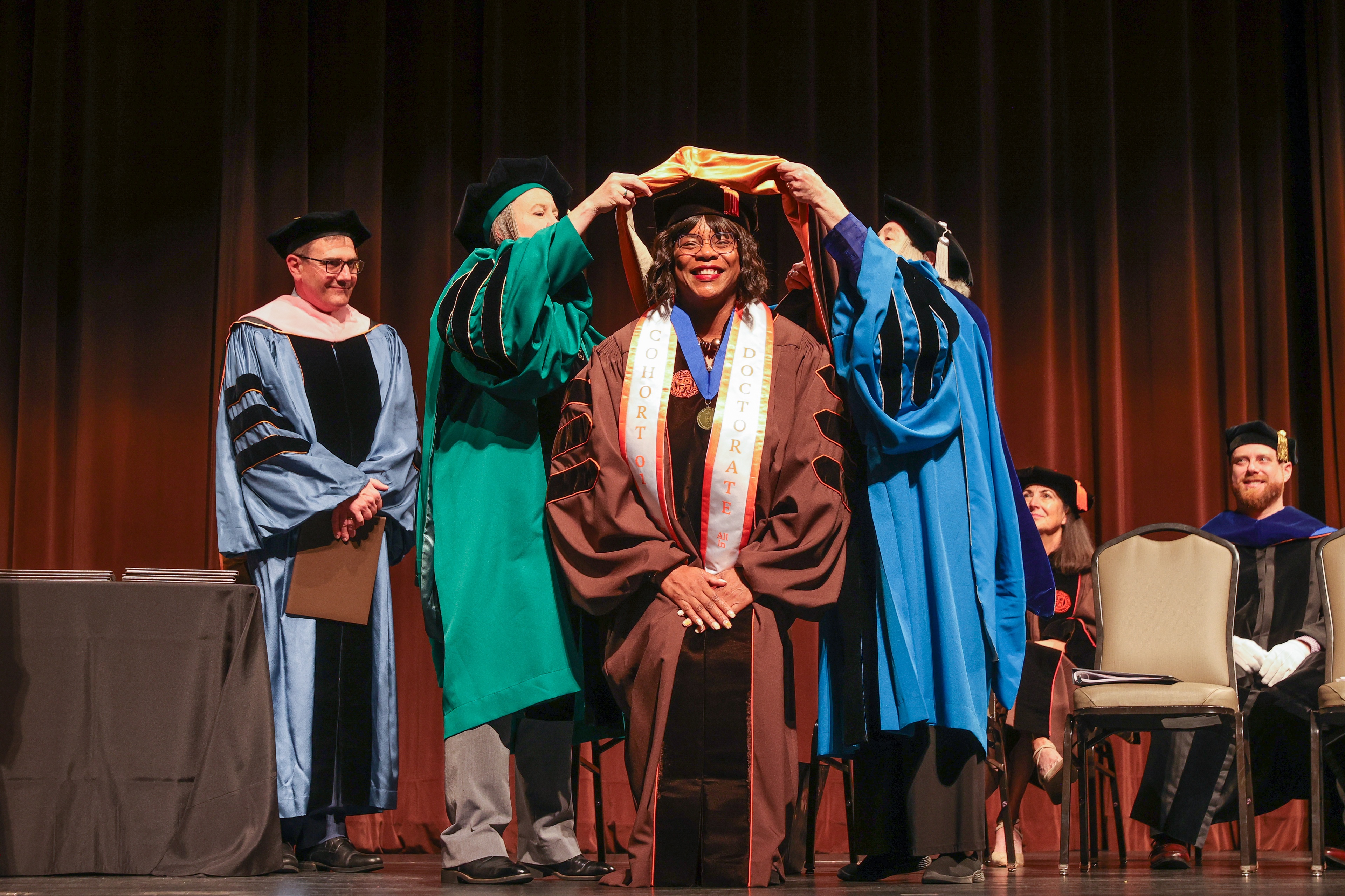 A BGSU doctoral student is hooded on stage at Kobacker Hall