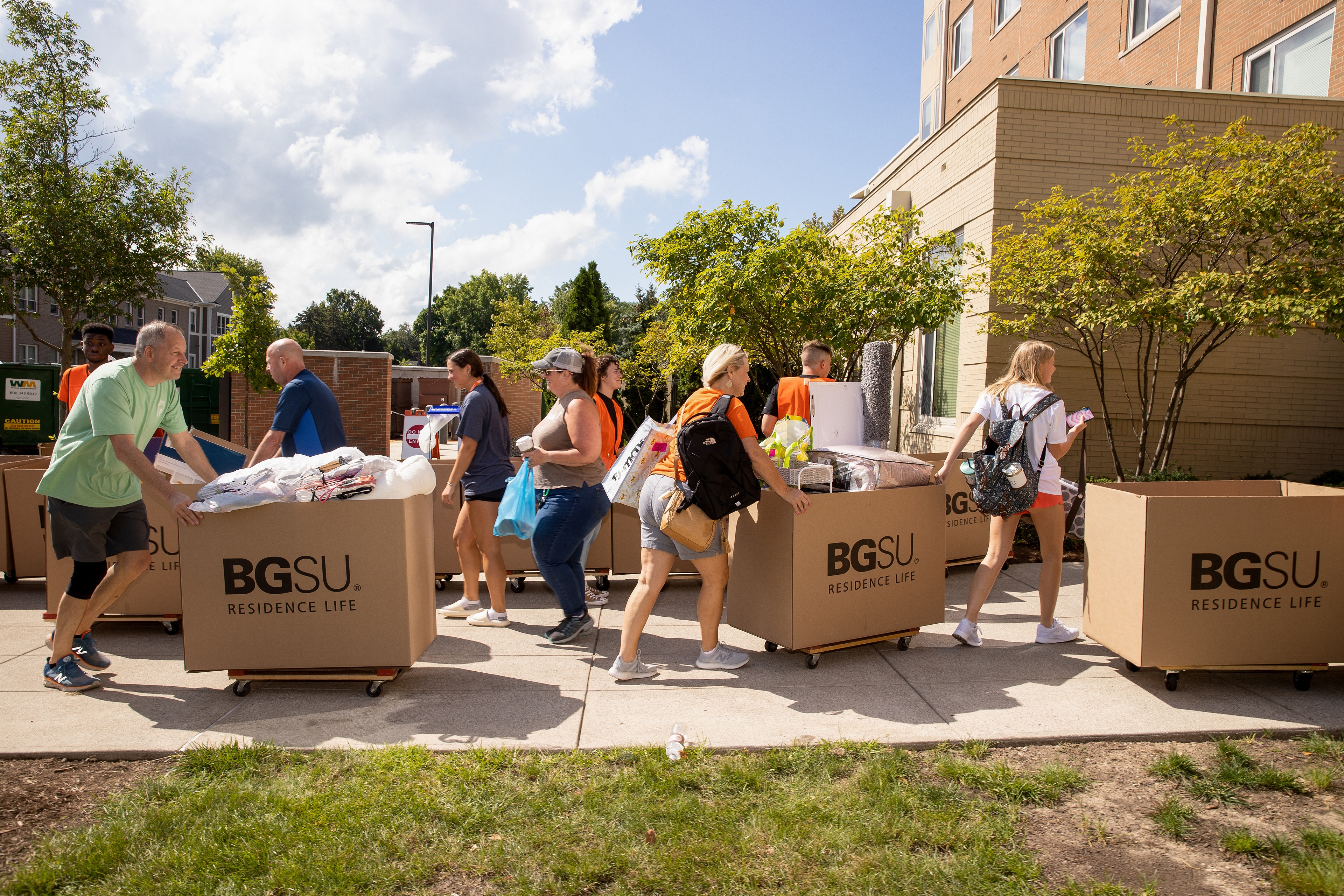 Parents and students push BGSU Residence Life large moving boxes on move-in day