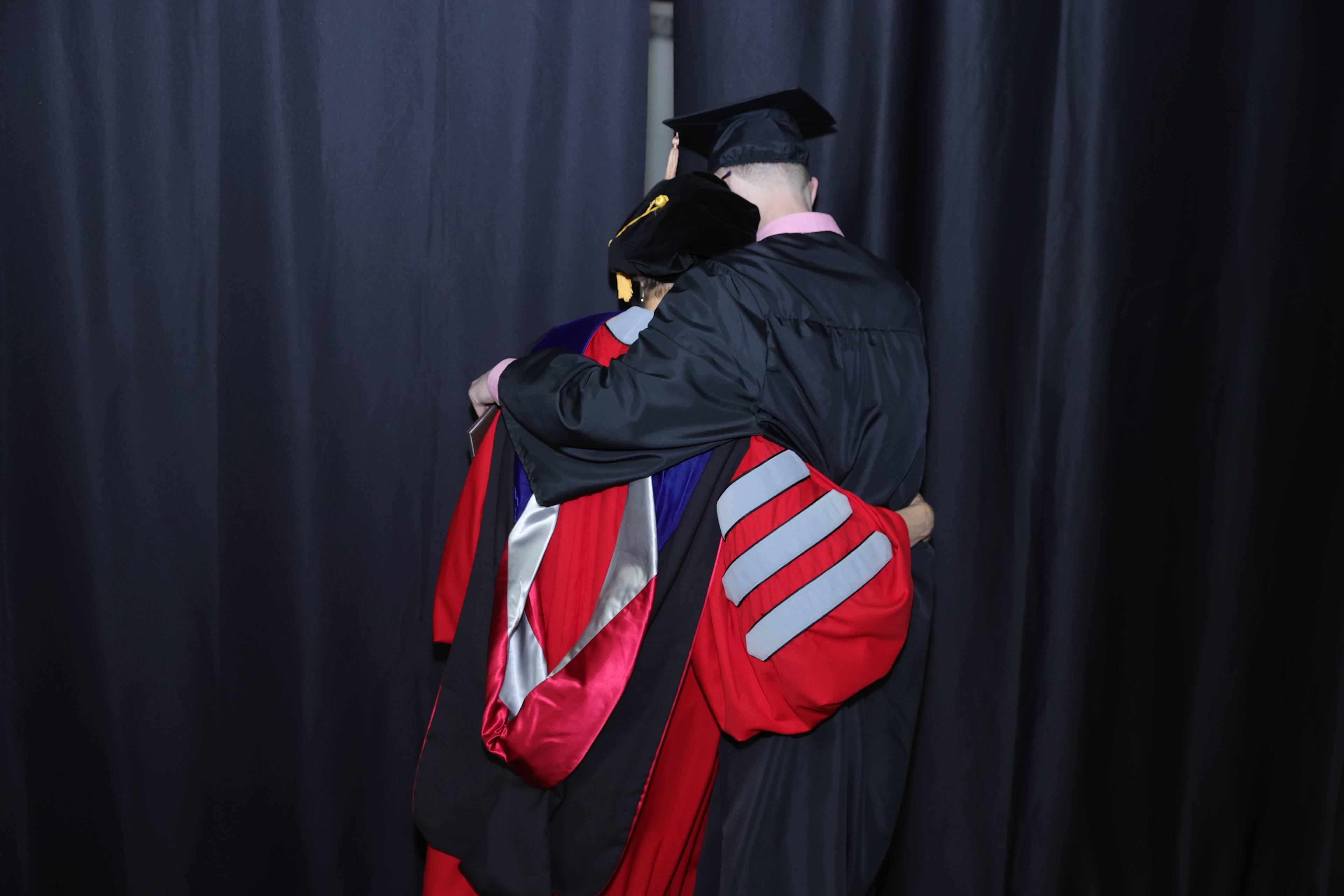 Dean Dawn Shinew and son Luther Shinew hug at his graduation  