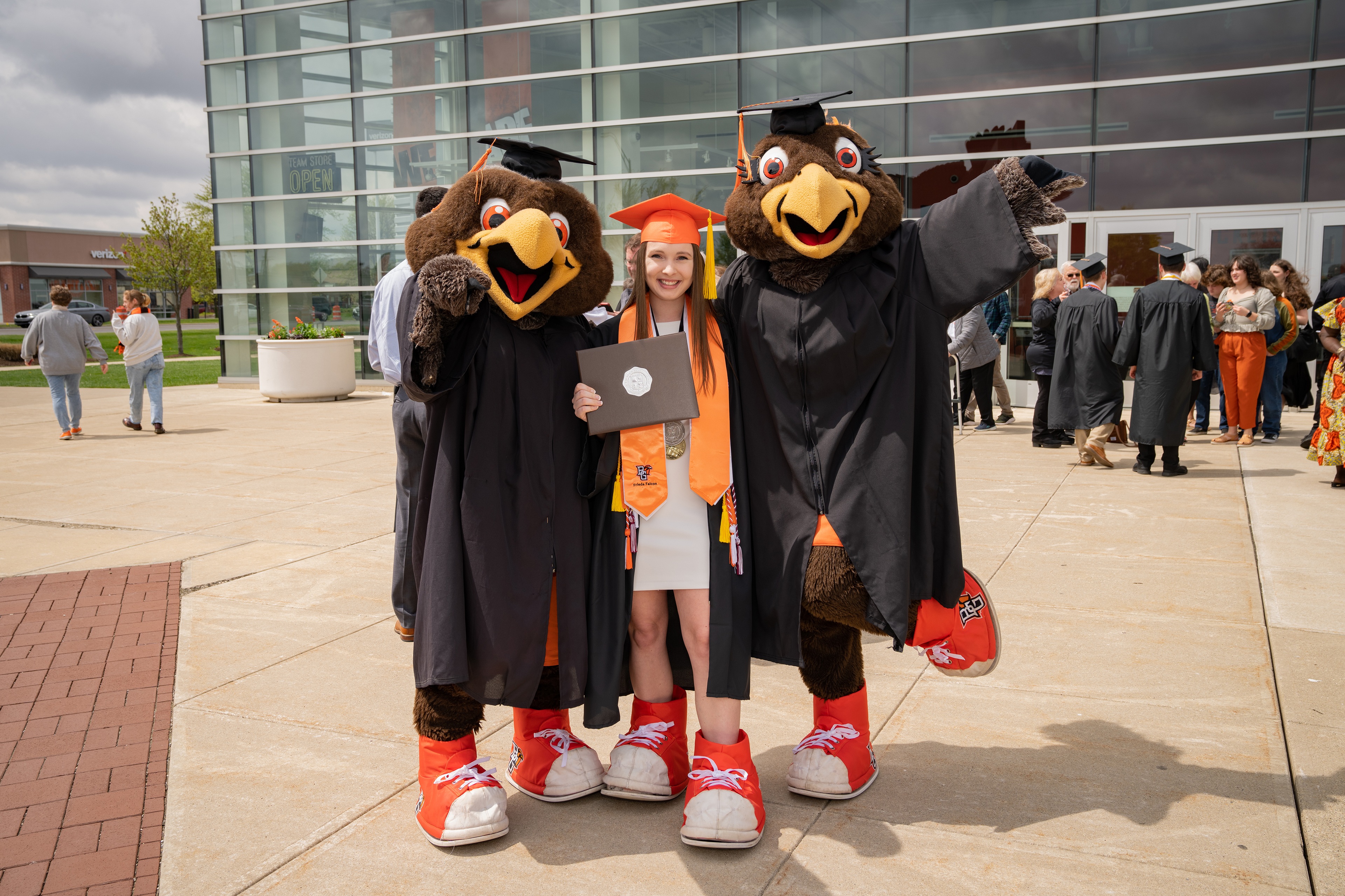 Graduate poses with Freddie and Frieda Falcon