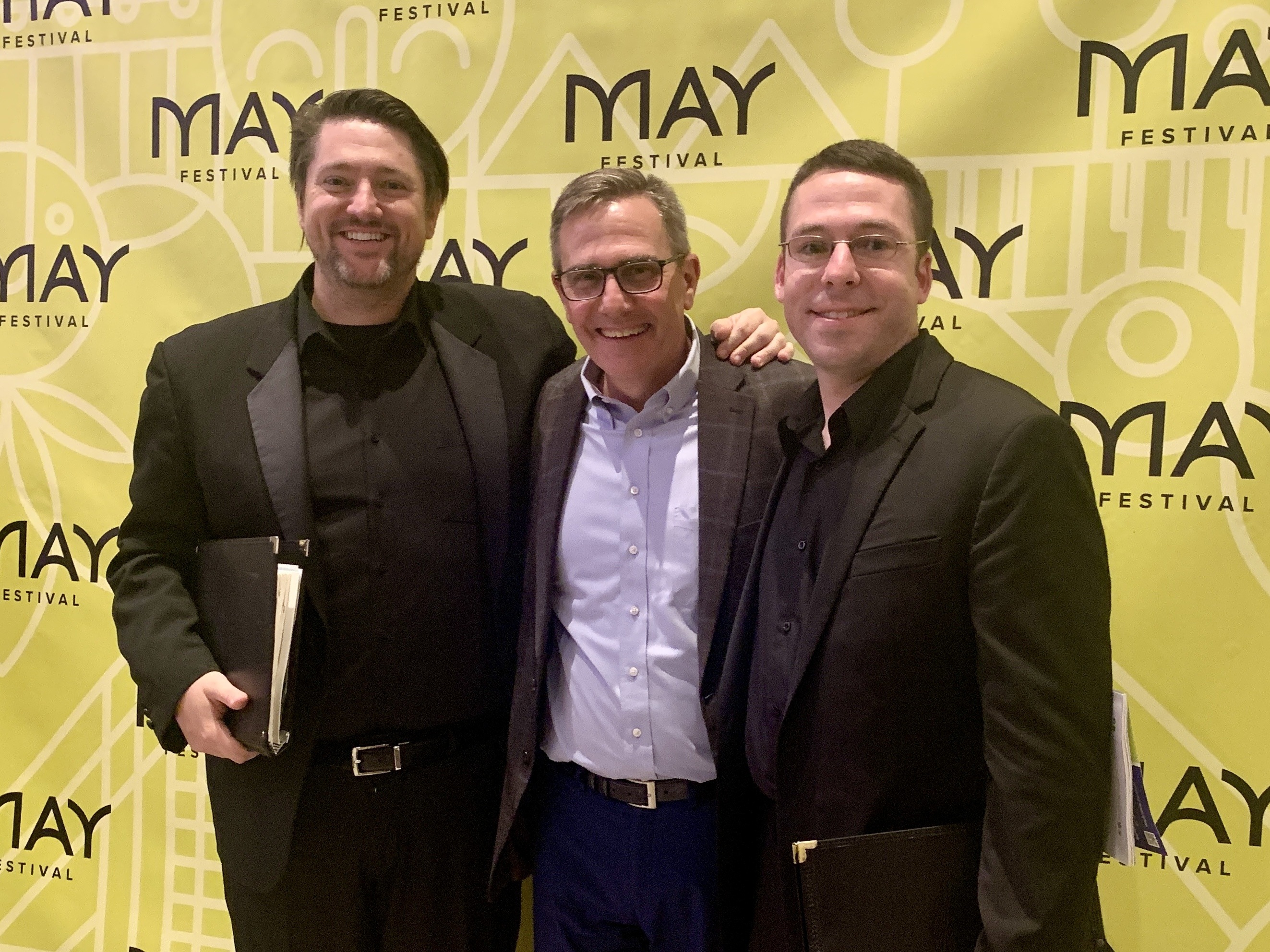 Two BGSU alumni pose with their former trombone professor at the Cincinnati May Festival.