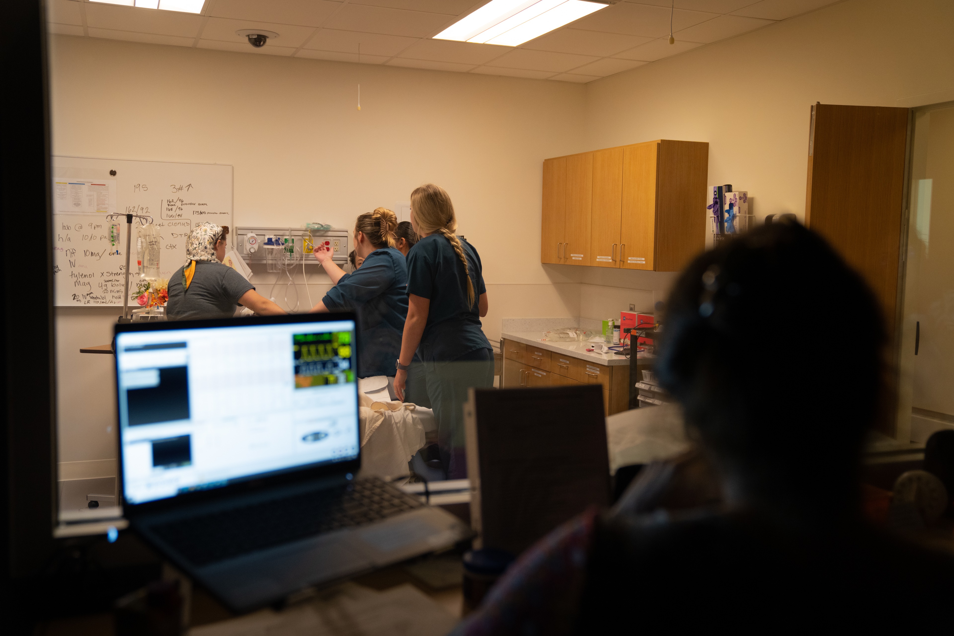 A group of people looking at a monitor and tending to a patient