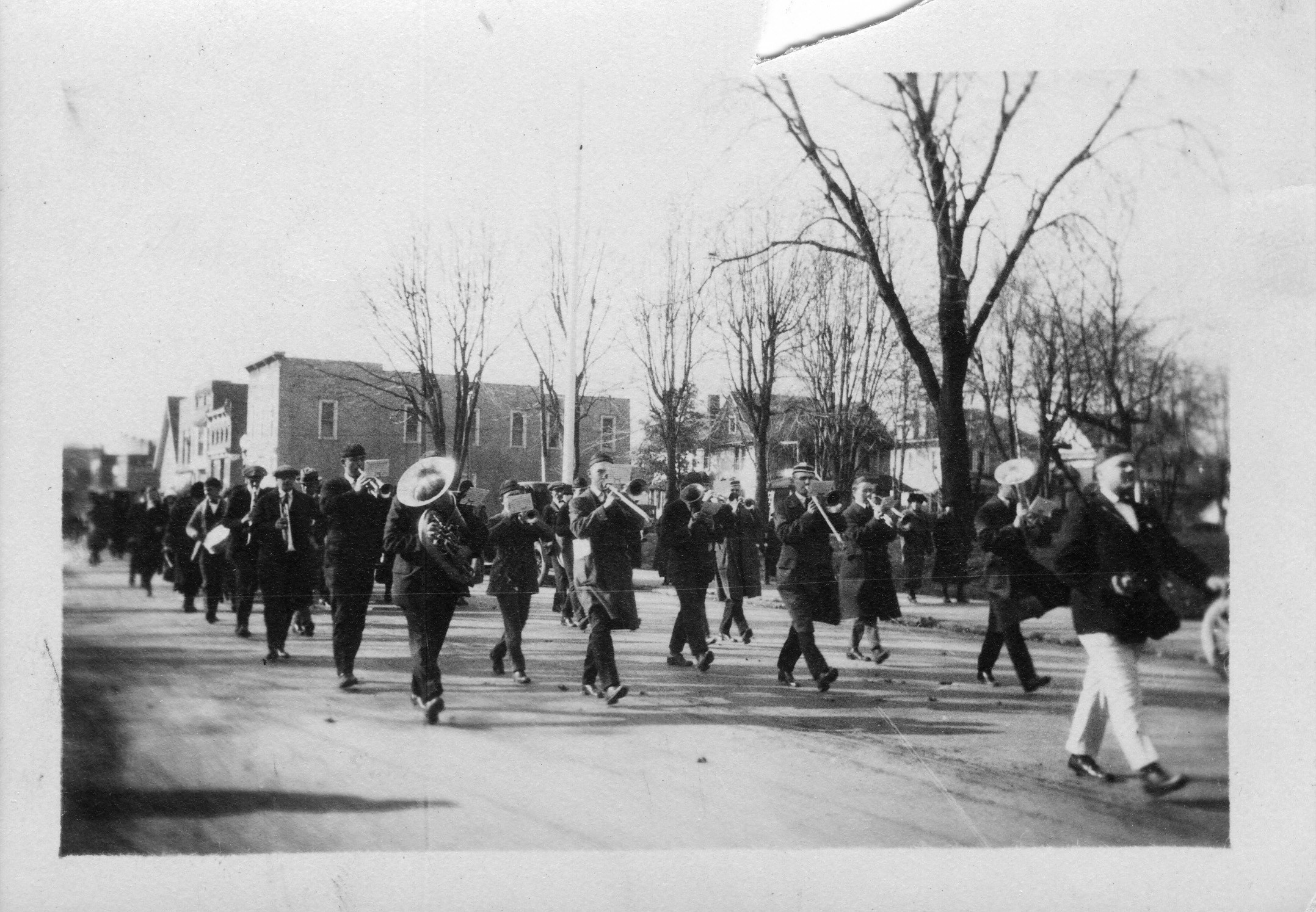 Historic photo of a marching band traveling down a street in Bowling Green