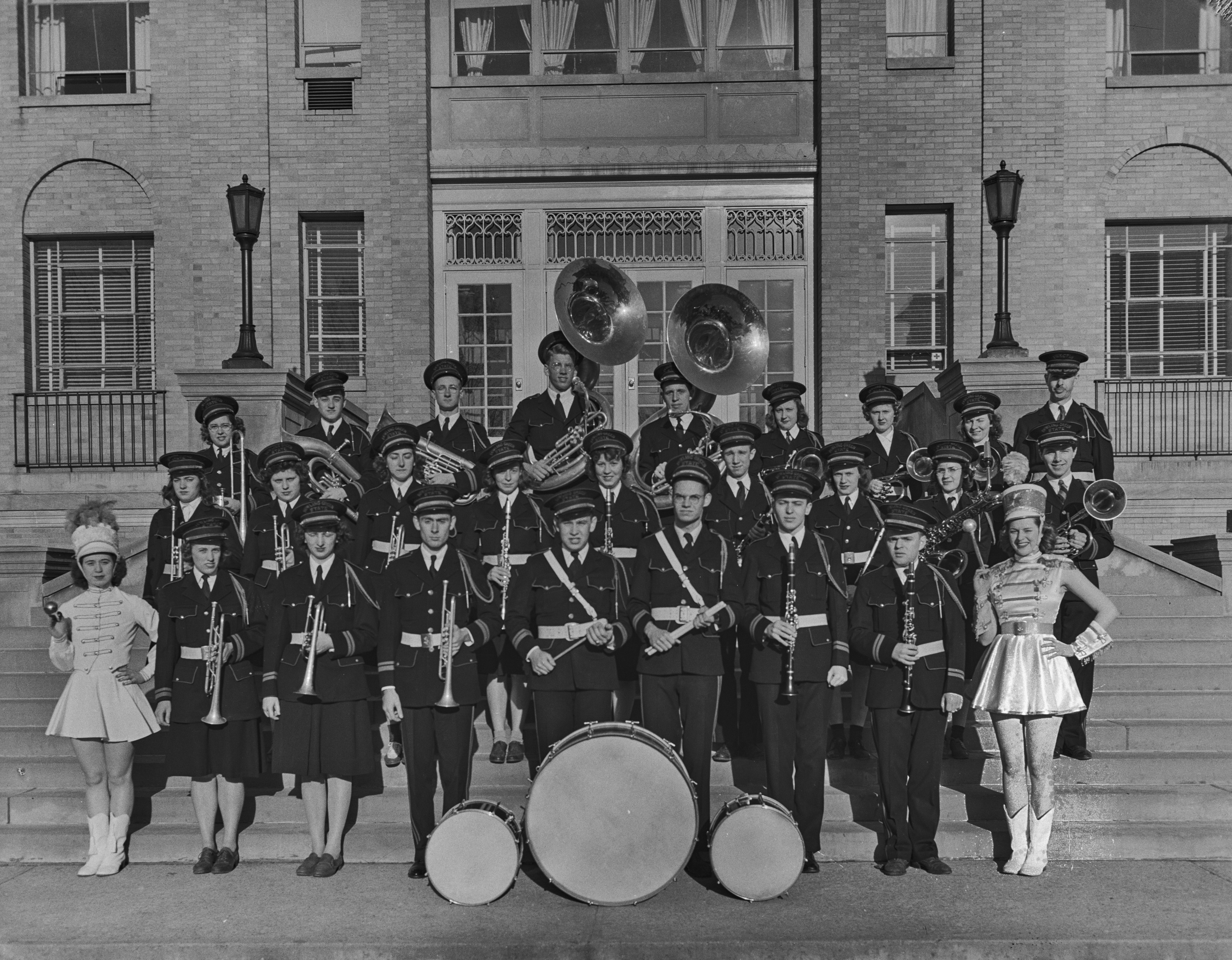 Historic photo shows the BGSU marching band posing in rows on the steps of University Hall in 1942. 