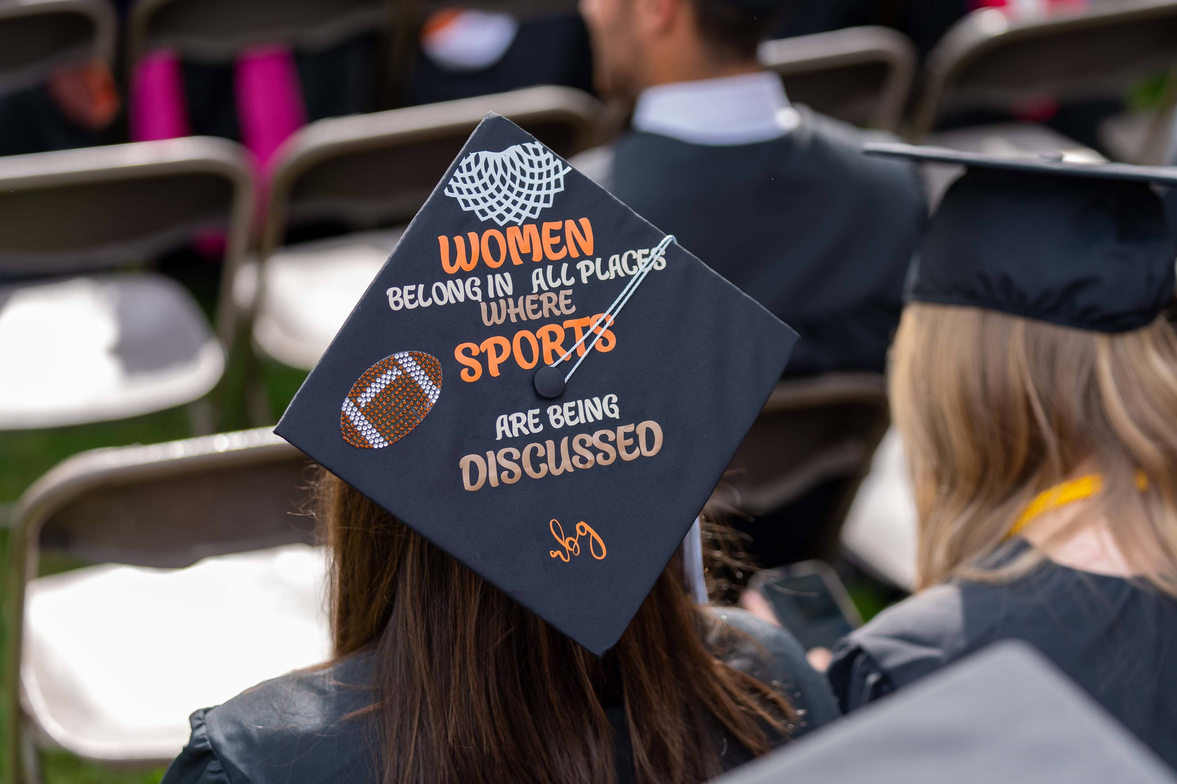 Graduation cap says, "Women belong in all places where sports are being discussed" 