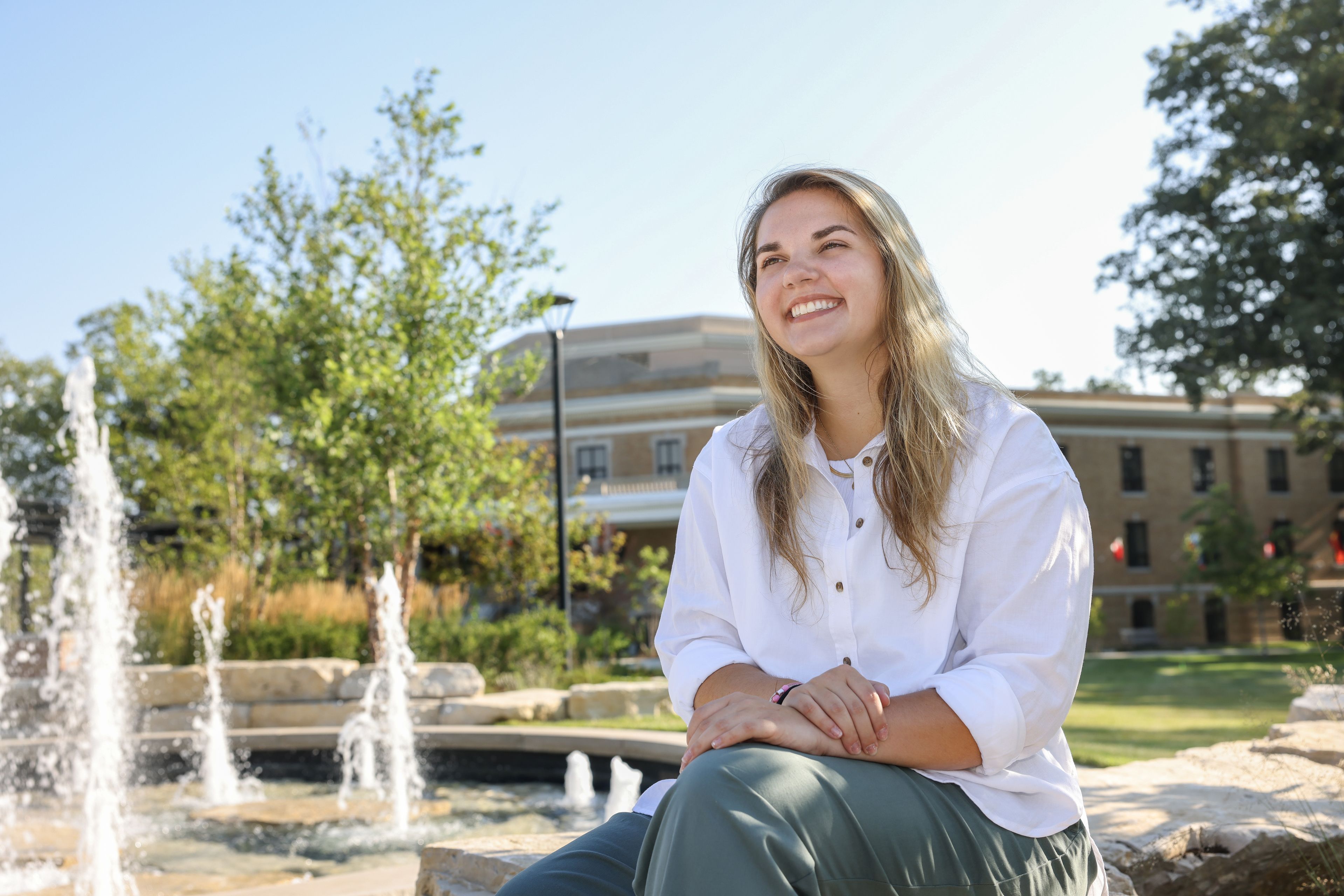 Karlee Augustus smiles as she sits on campus.