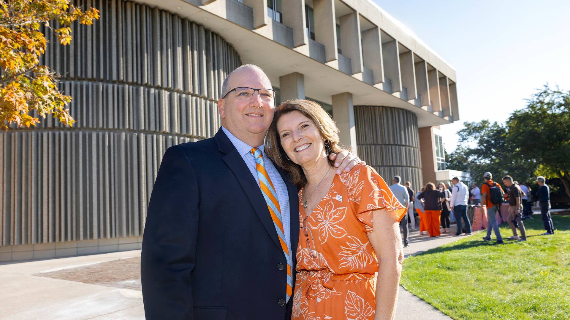 BGSU alumni Mitchell and Julie McLeod pose in front of Mitchell B. McLeod Hall