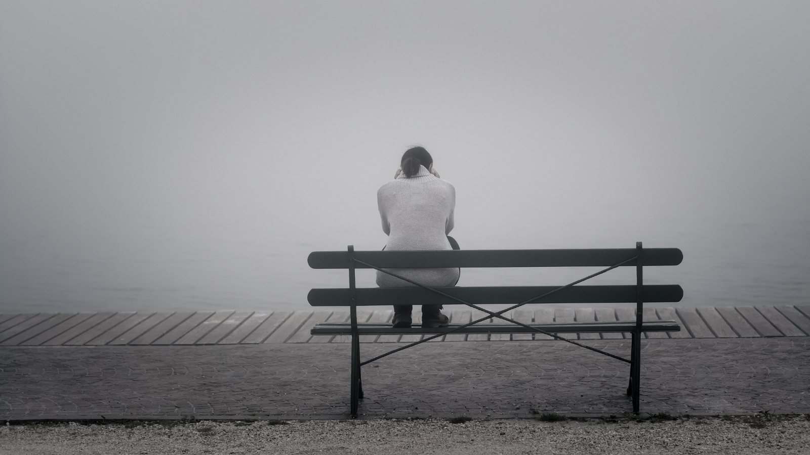A woman sits on a bench alone
