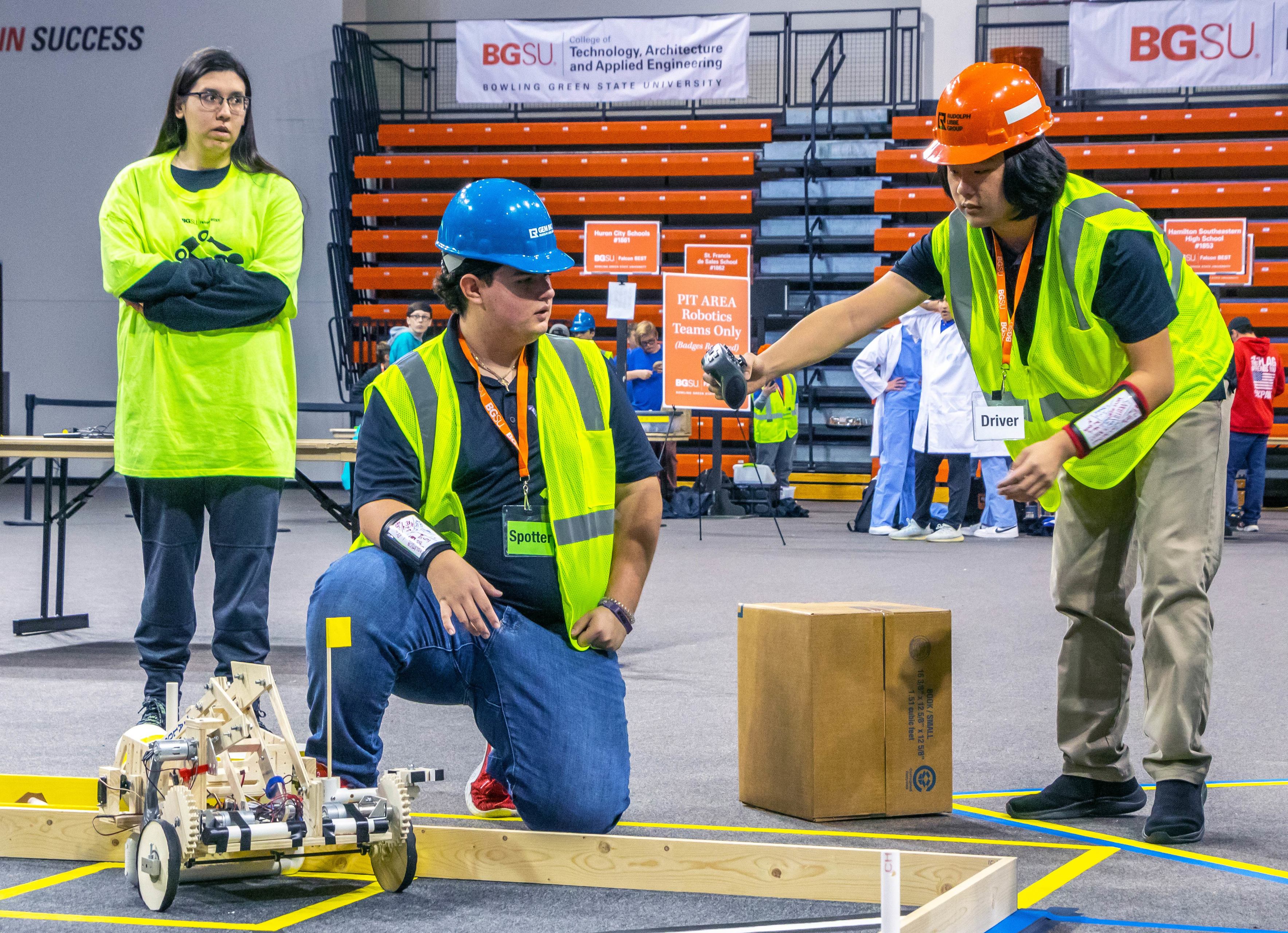 Two people operate a robot during a competition at BGSU.