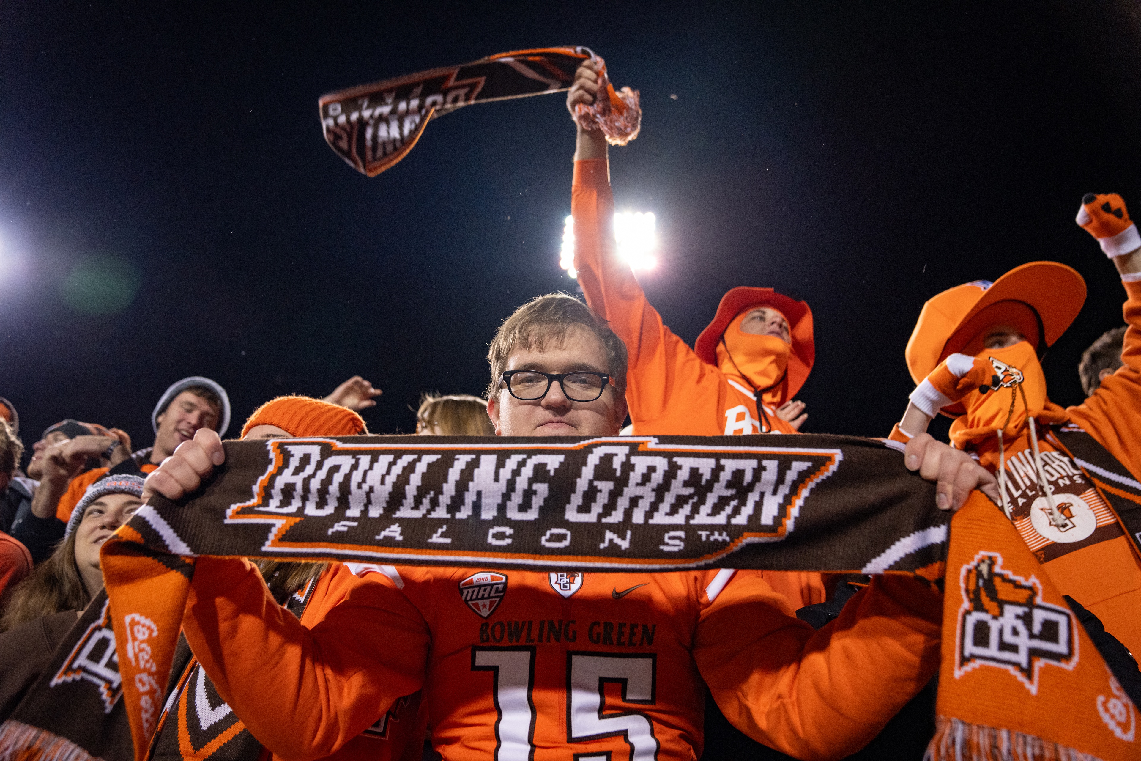 Falcon fans stand at Doyt Perry Stadium holding BGSU knit scarves 