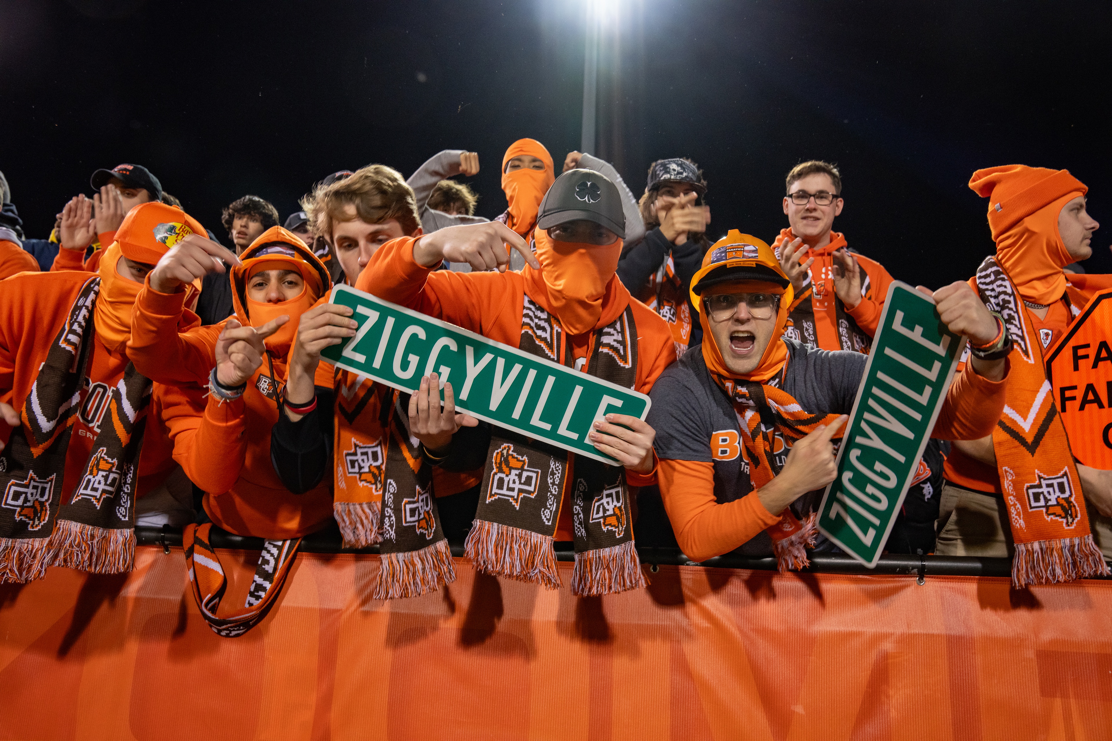 BGSU football fans wearing orange hold up Ziggyville signs