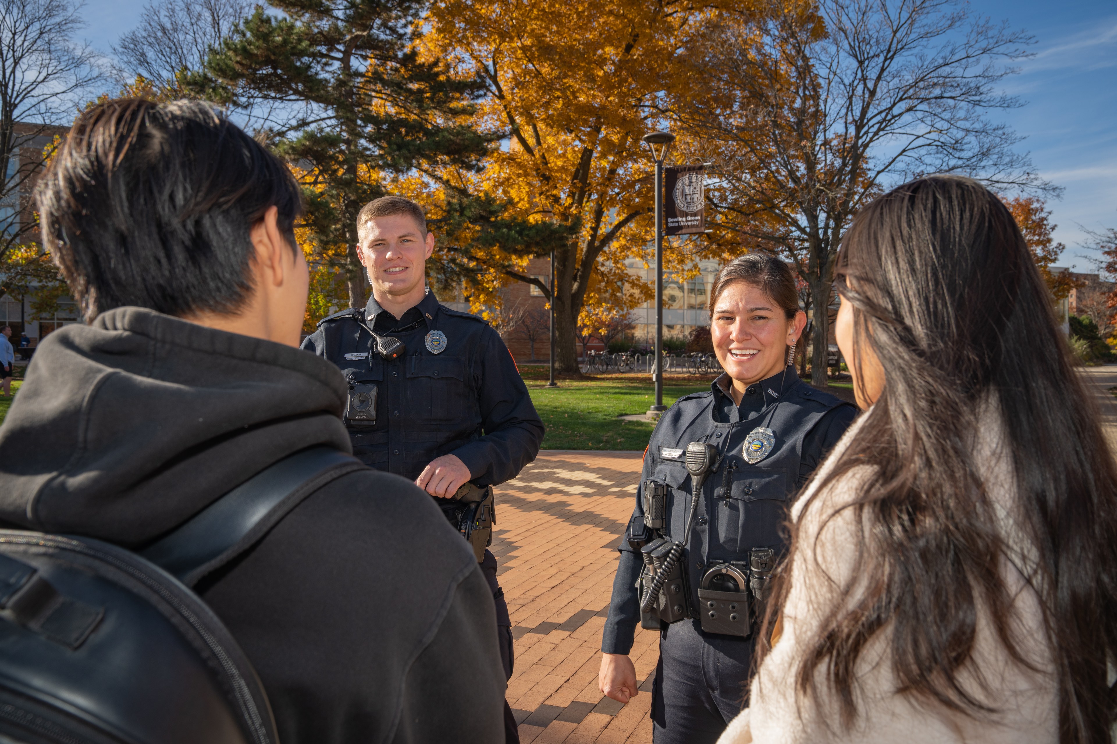 Two BGSU Police officers chat with students outside the Bowen-Thompson Student Union on campus.