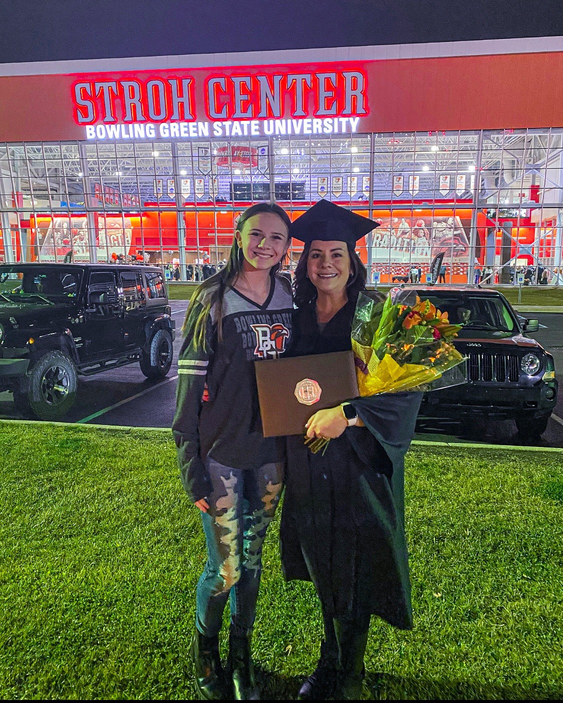 Kasandra Garcia holding a diploma posing for a photo with her daughter, Gracie