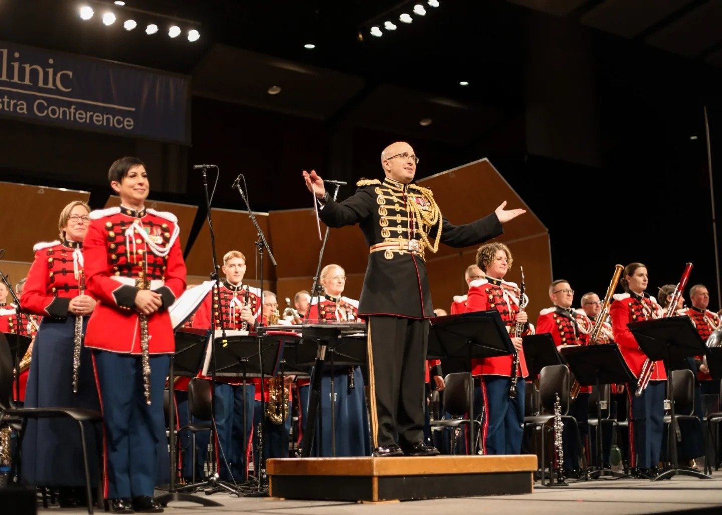 U.S. Marine Band Director Lt. Col. Ryan Nowlin raises his arms at the end of a performance