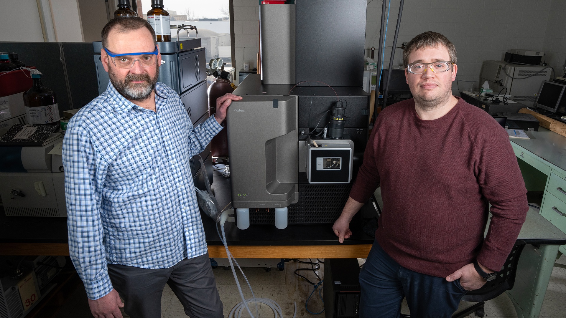 Dr. Joe Furgal and Dr. James Metcalf stand in front of a new high-resolution mass spectrometer inside of a lab at BGSU. 