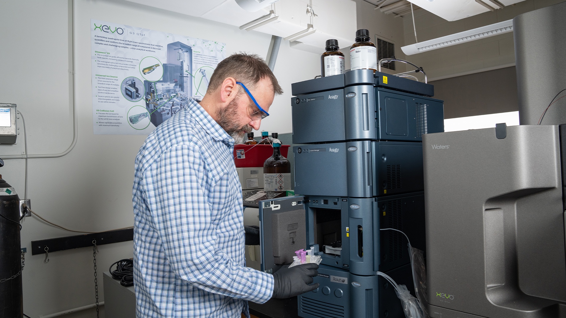 Dr. James Metcalf removes a tray of samples from a high-resolution mass spectrometer. 