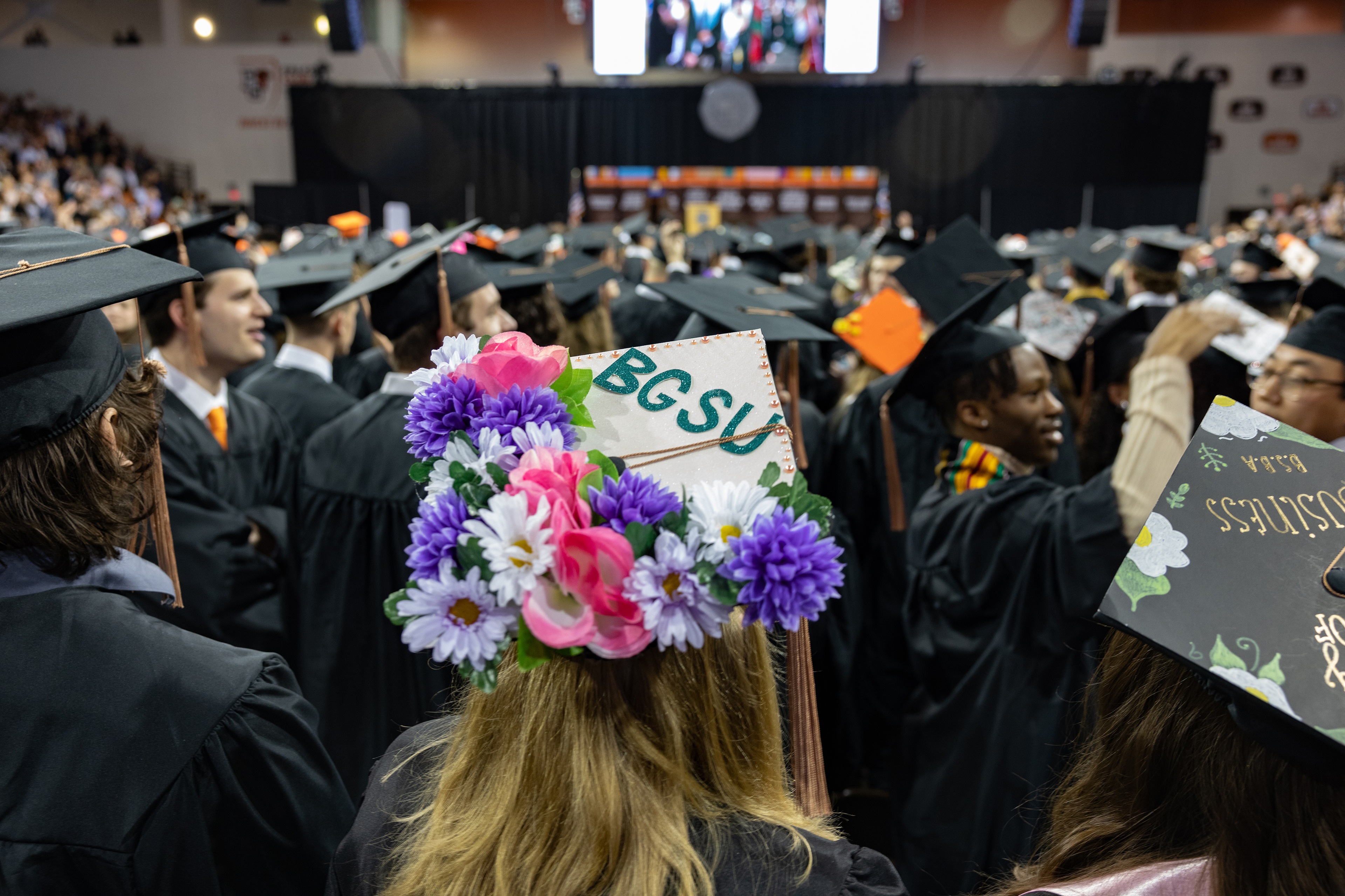 Graduation cap spells out BGSU on a field of flowers