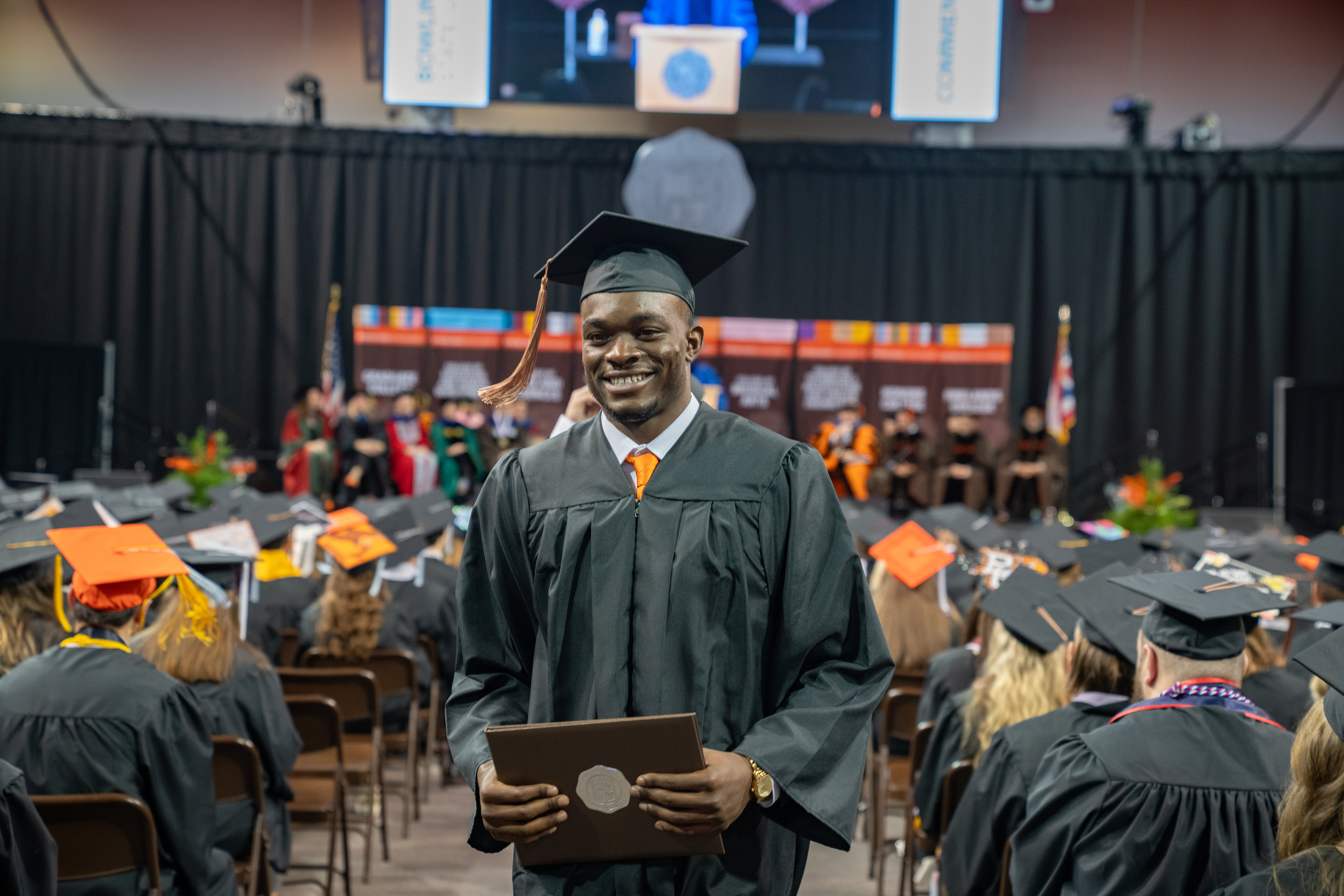 BGSU graduate Odieu Hiliare holds his diploma cover 