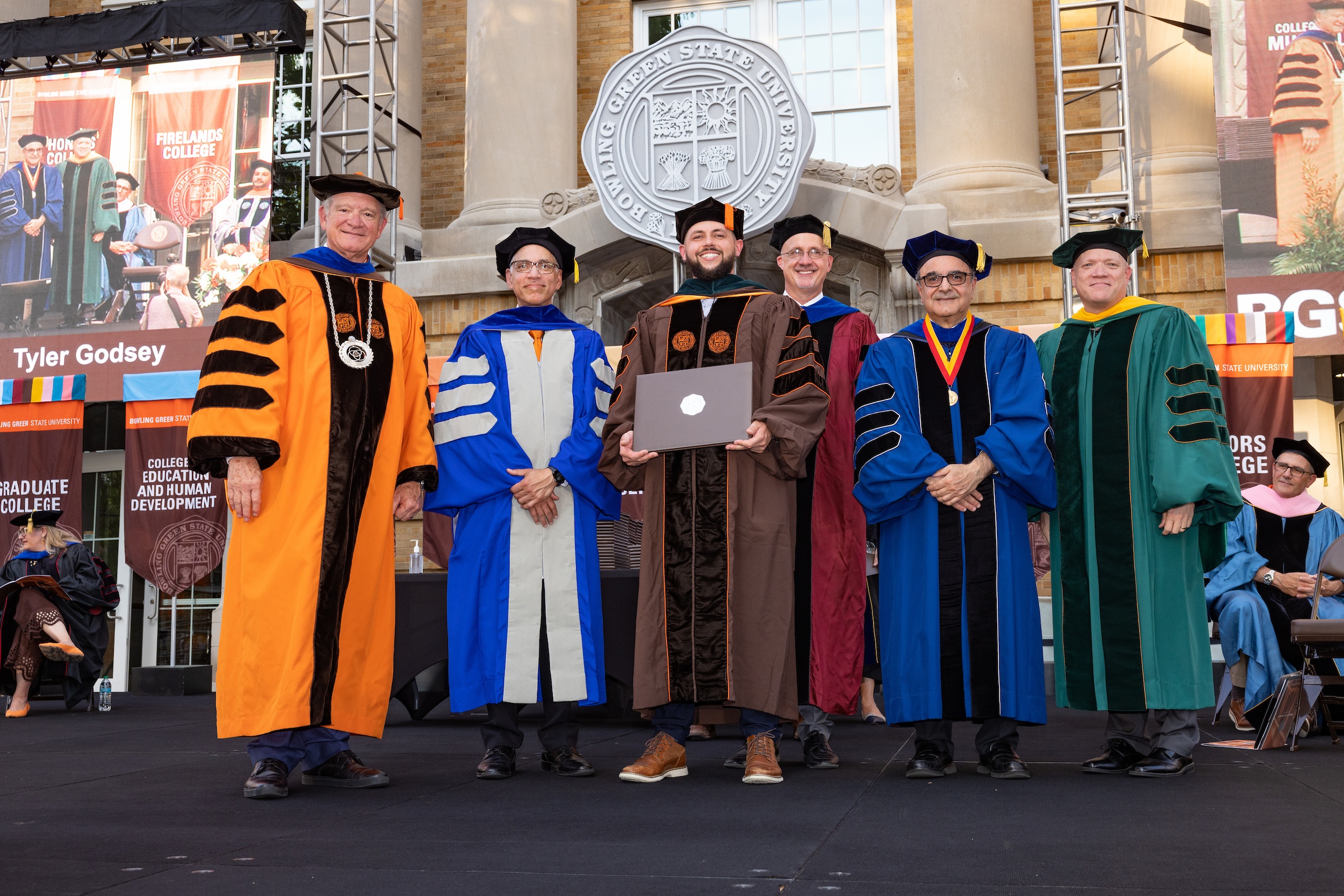 A graduate on stage with BGSU dignitaries