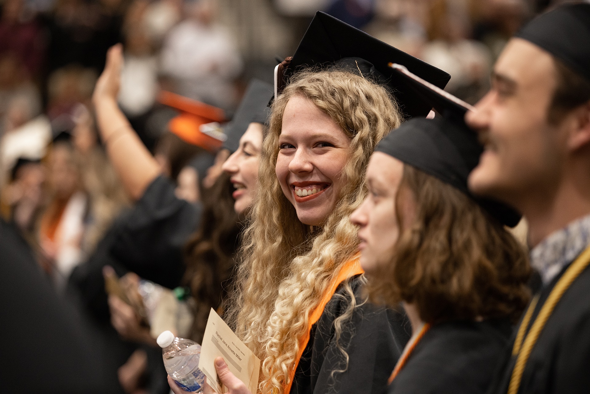 A graduate smiles at the camera.