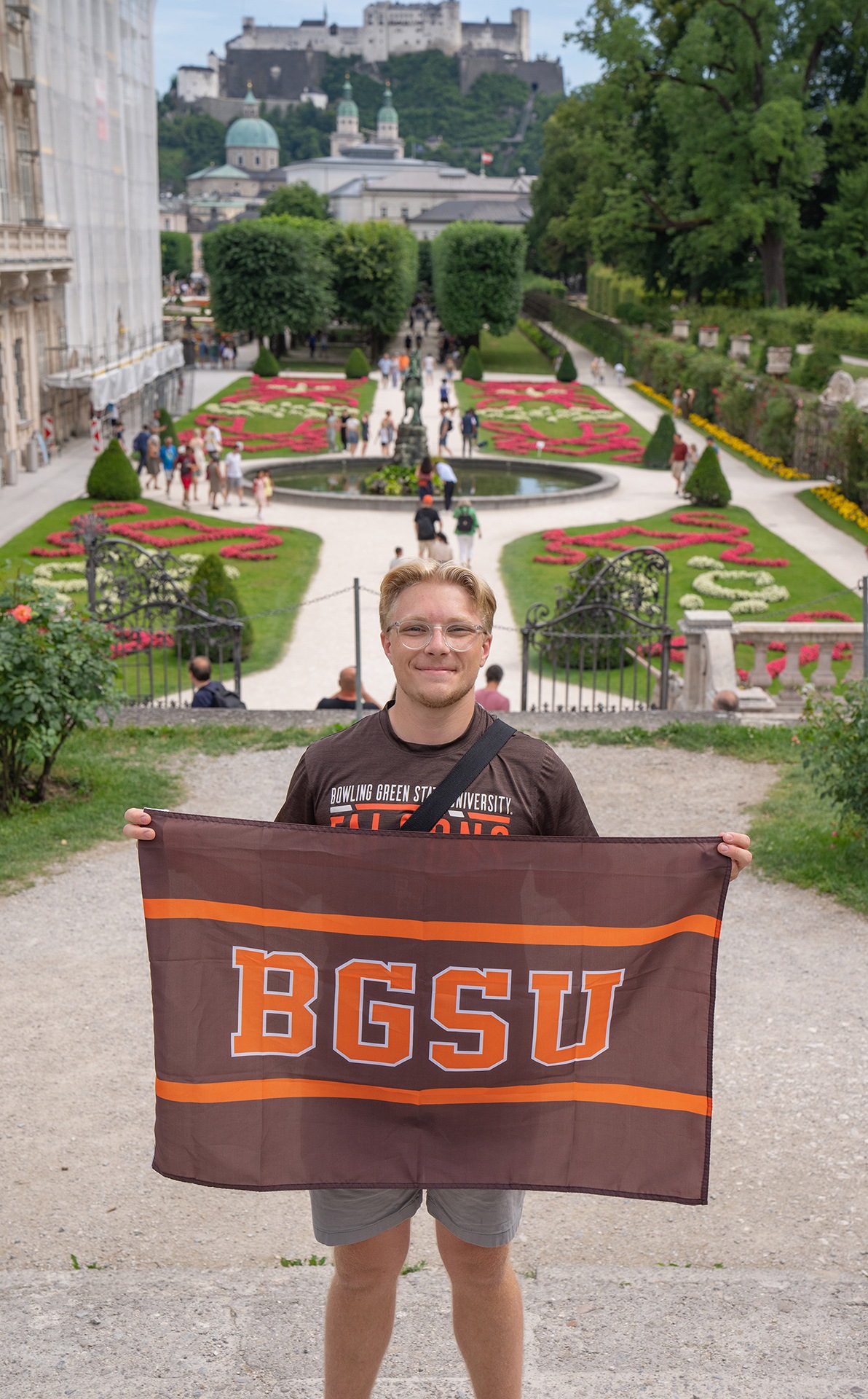 a student holding a BGSU flag in Salzburg Austria