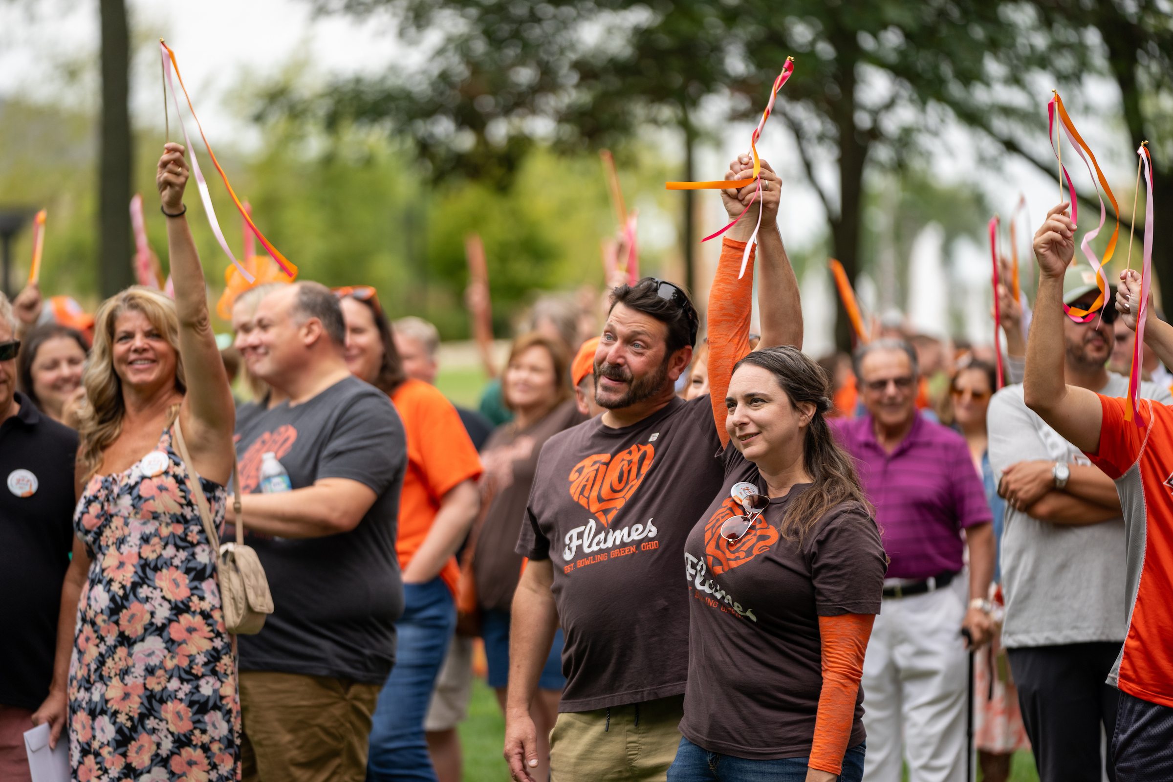 People hold ribbons in the air during a vow renewal ceremony
