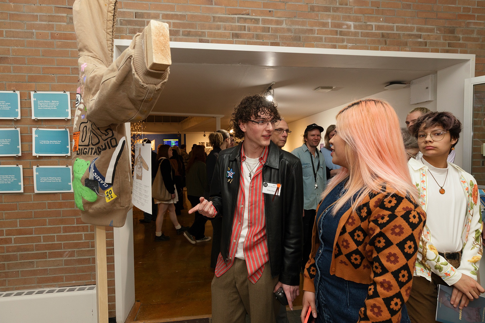 People view an artistically designed jacket at an art show