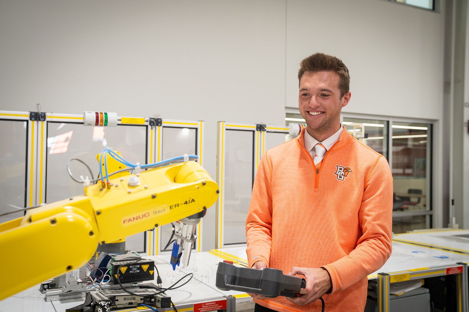 A person holds a controller while working with robotics.