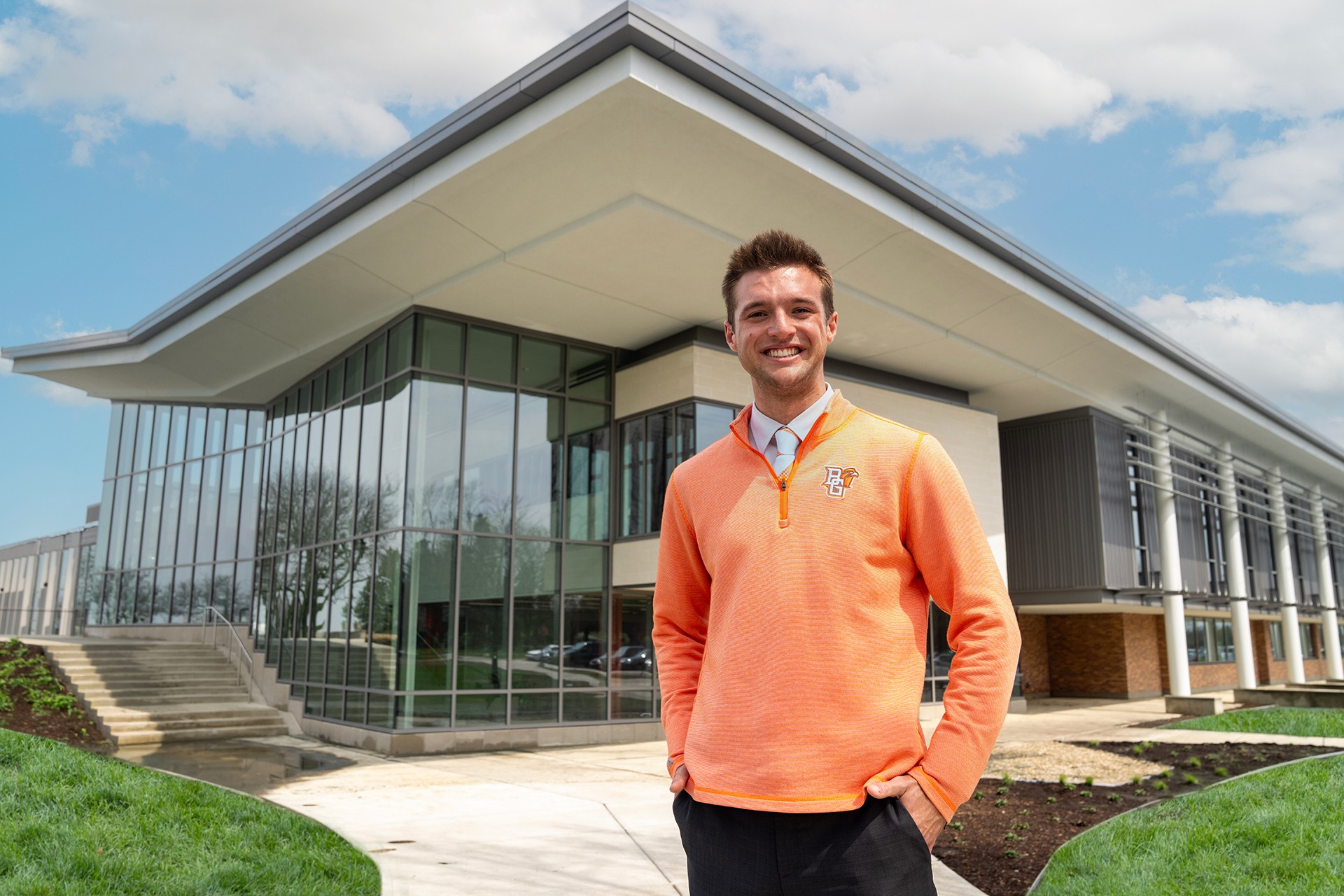 A person poses for a picture in front of a building.